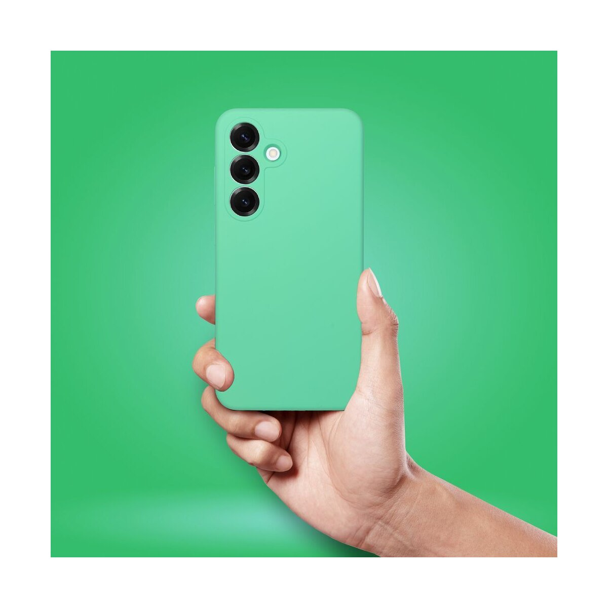 Eine Hand hält ein türkisfarbenes Smartphone mit drei Kameras auf grünem Hintergrund.