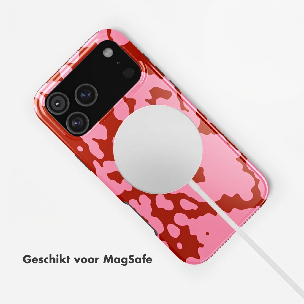 Rode iPhone met roze vlekkenpatroon en MagSafe-oplader.