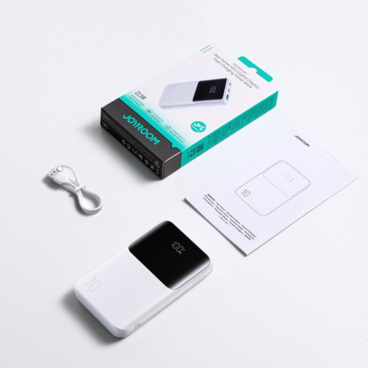 Ein weißes JOYROOM Powerbank-Set mit Verpackung, Kabel und Anleitung auf weißem Hintergrund.