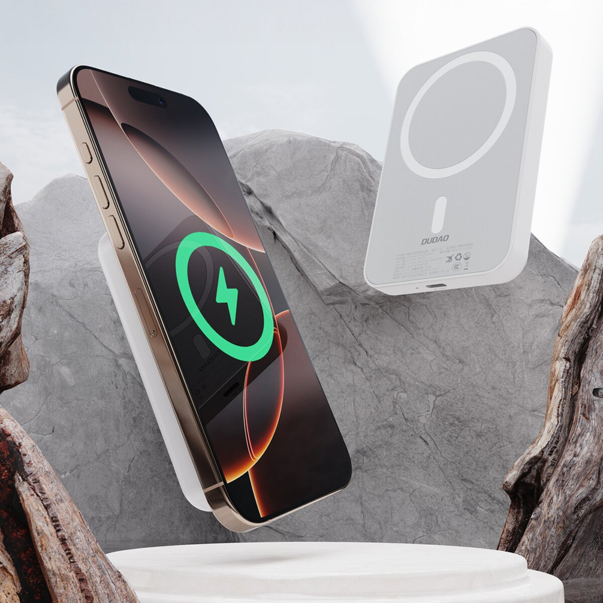 Ein Smartphone wird kabellos von einem weißen Ladegerät geladen, umgeben von Felsen.
