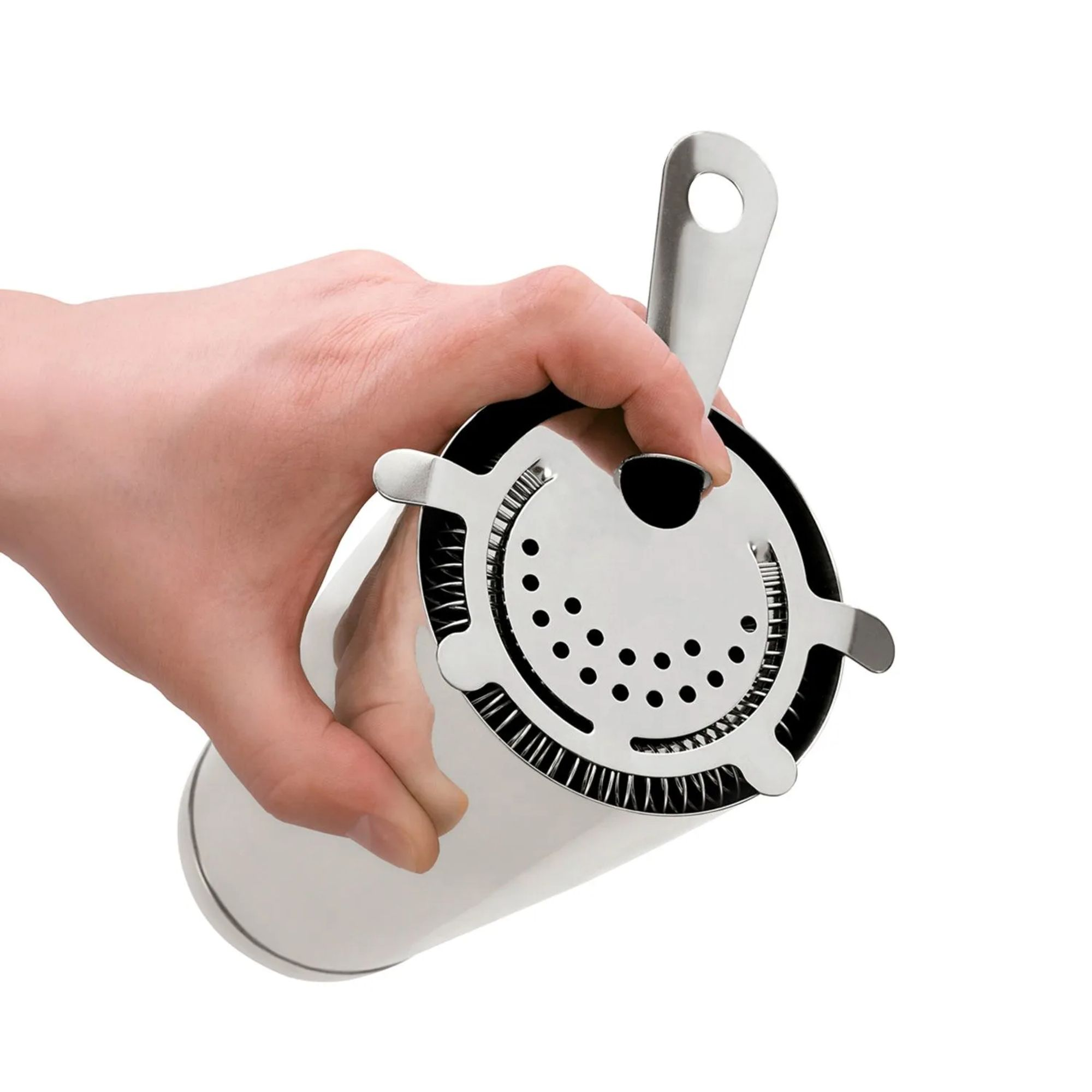 Una mano tiene uno strainer per cocktail argentato con manico e foro.