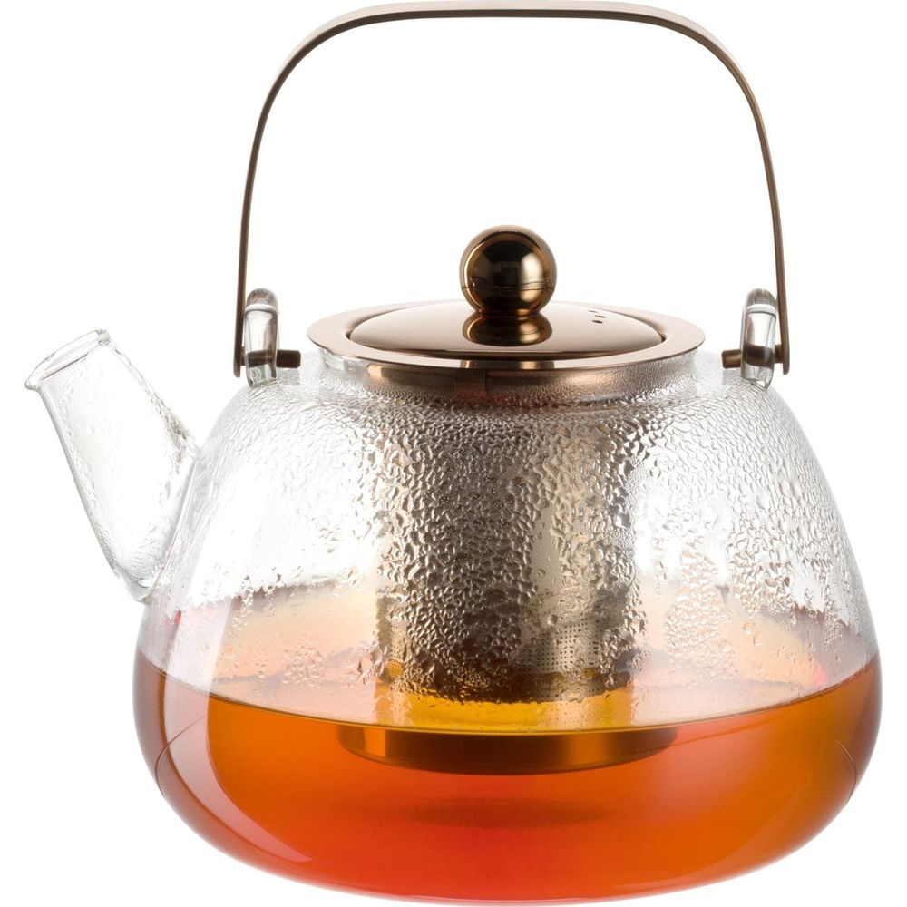 Glas-Teekanne mit Kupferdeckel und Henkel, gefüllt mit Tee.