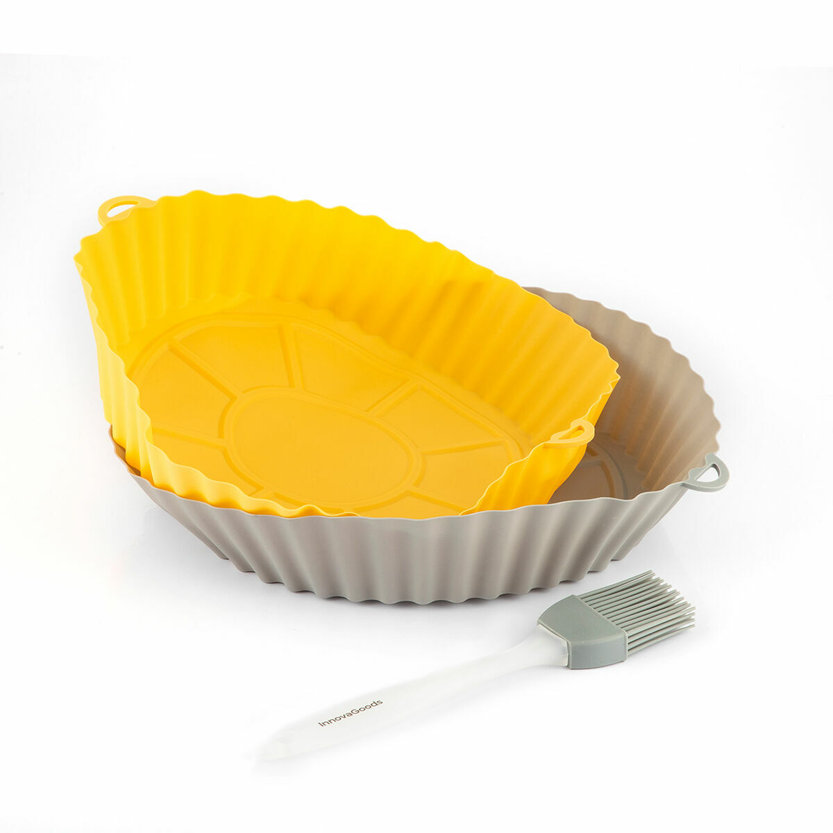 Due stampi da forno in silicone, giallo e grigio, con un pennello.