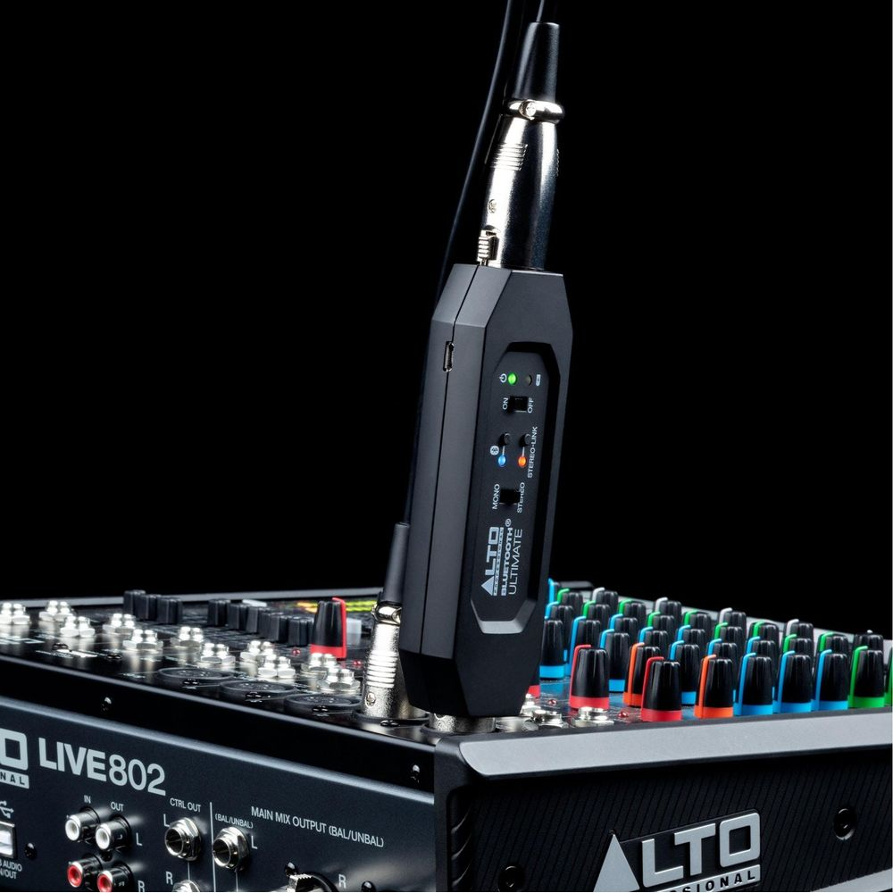 Un ricevitore Bluetooth nero collegato a un mixer audio.