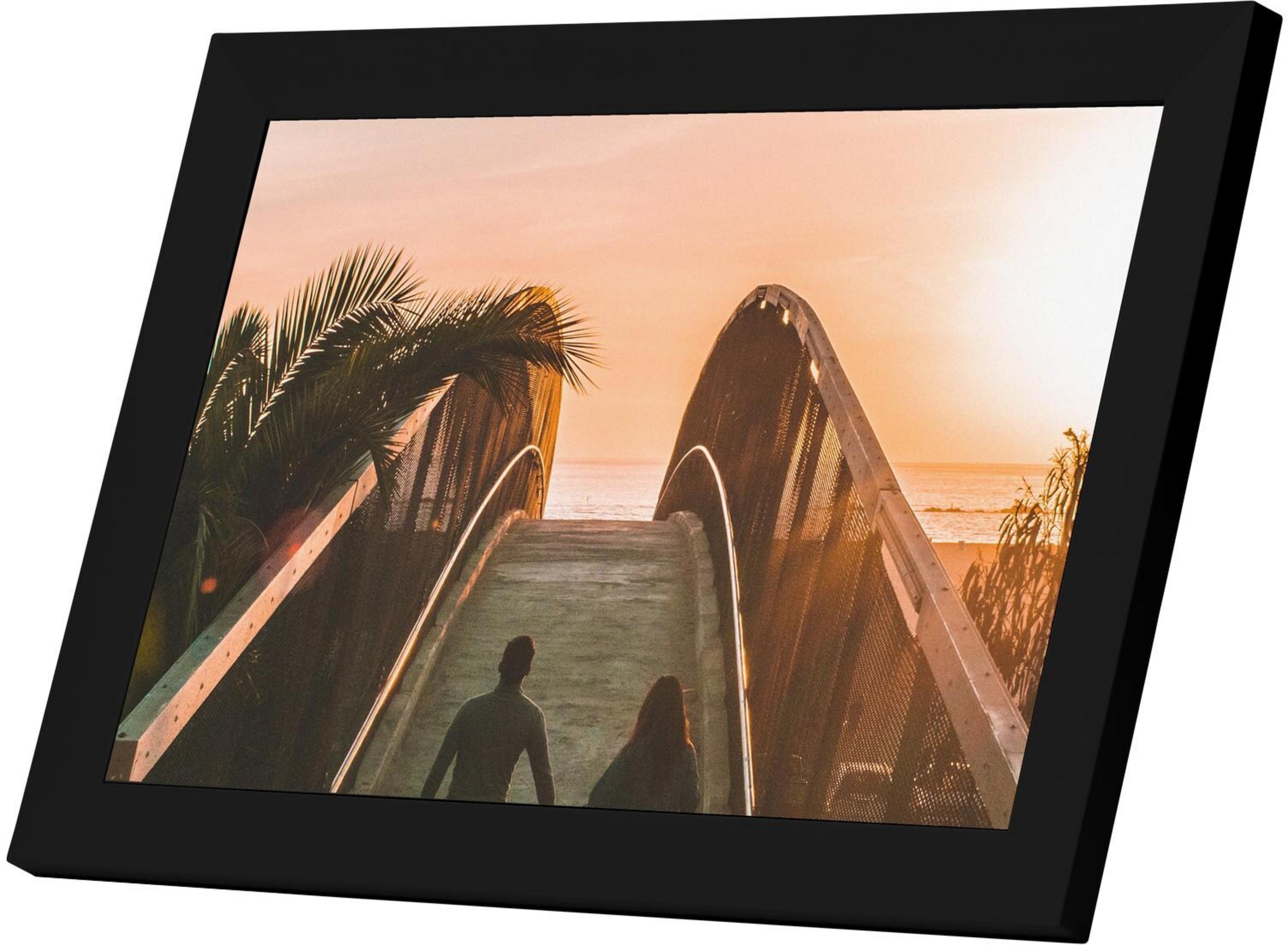 Paar geht bei Sonnenuntergang auf einer Brücke mit Palmen und Meer.