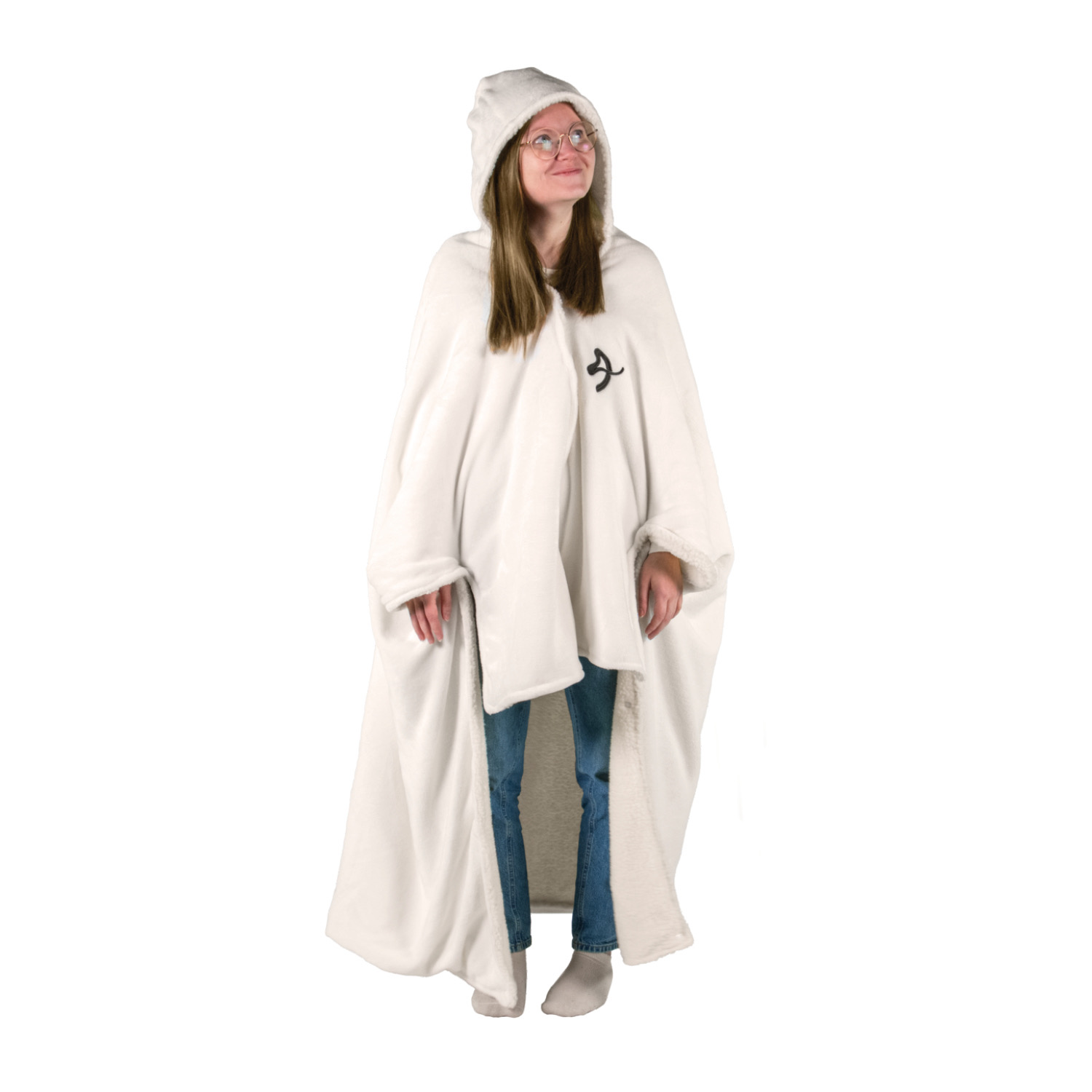 Una donna con occhiali indossa un mantello bianco con cappuccio, jeans e calzini.