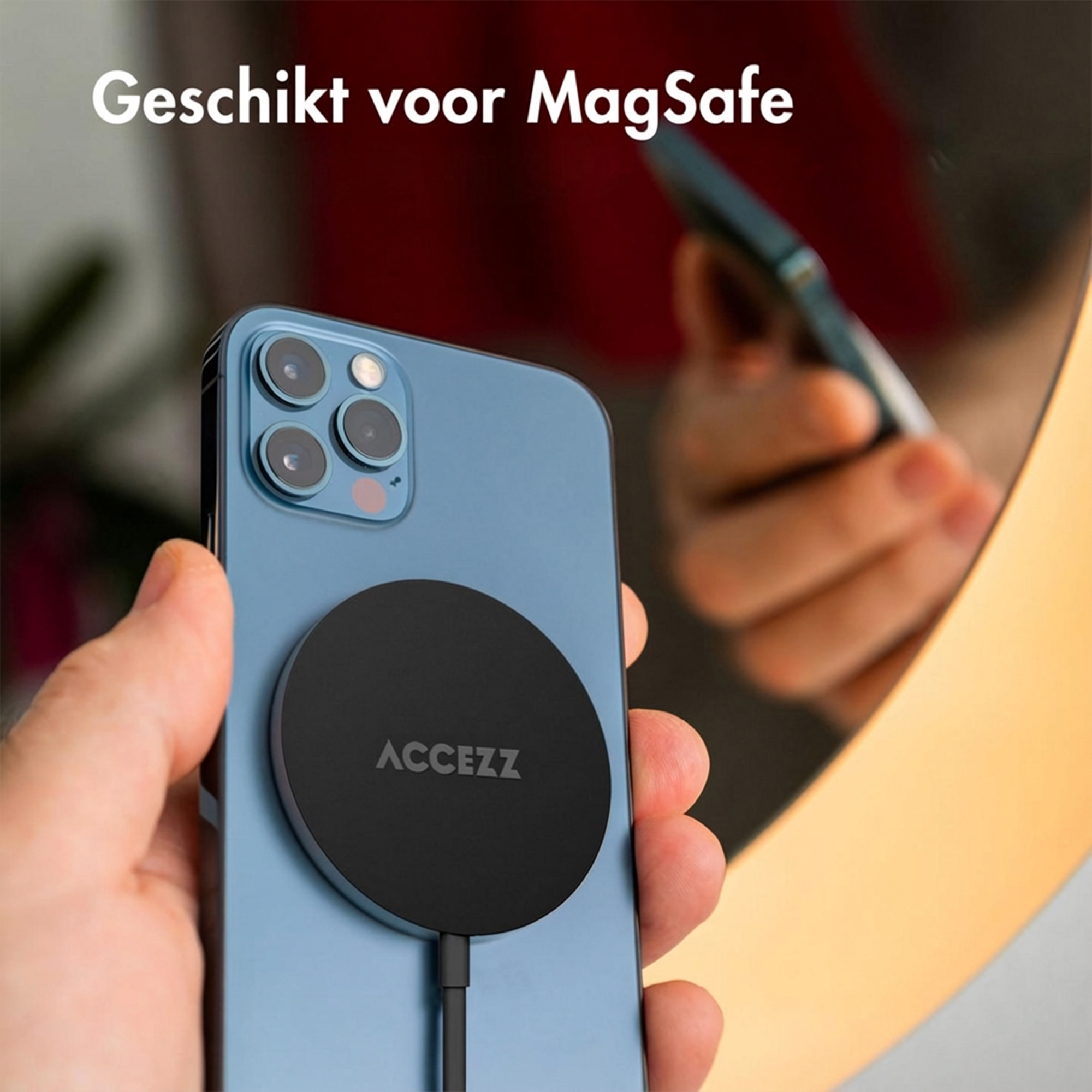 A blue iPhone back with a black MagSafe charger, held by a hand.