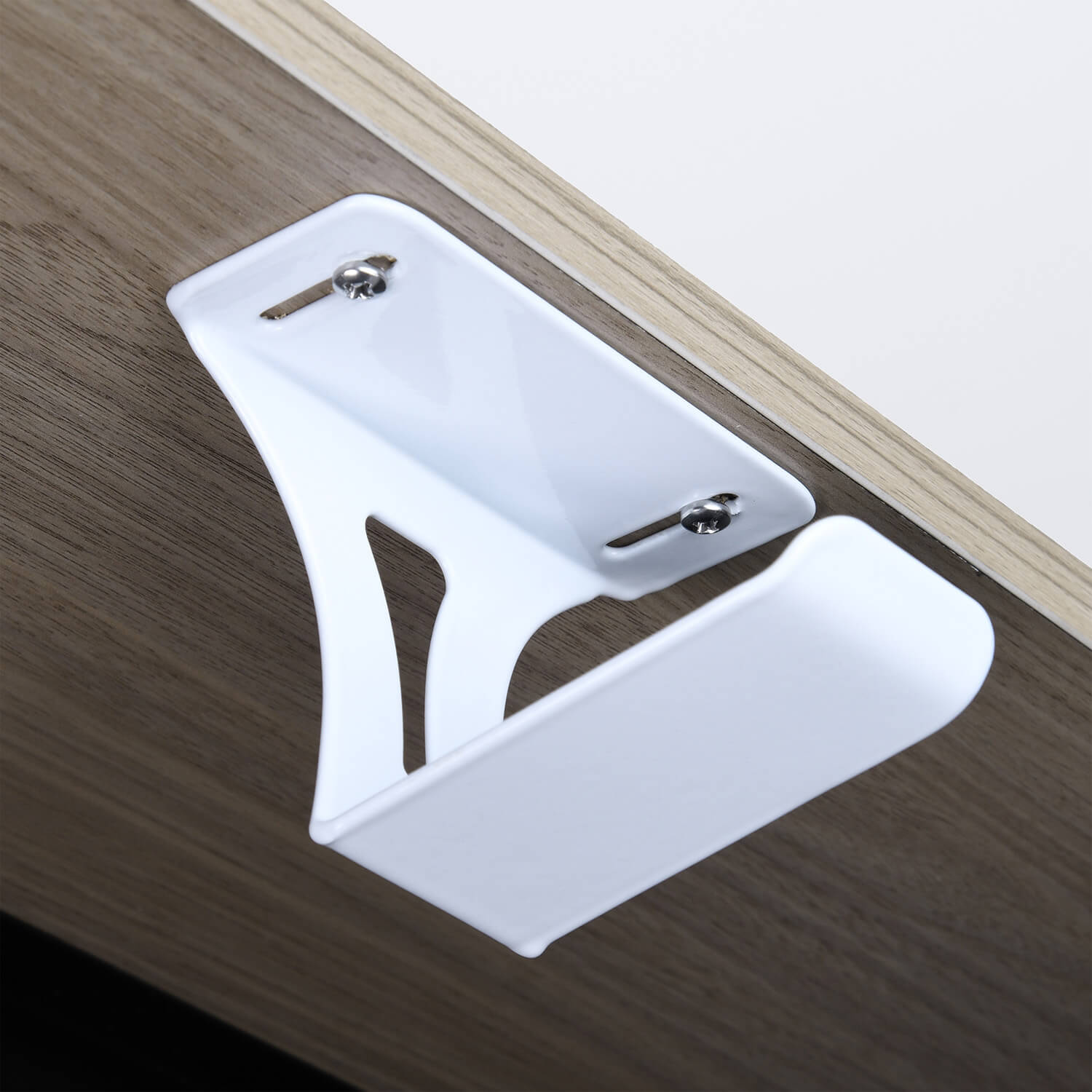 Un gancio bianco è fissato a una scrivania di legno.