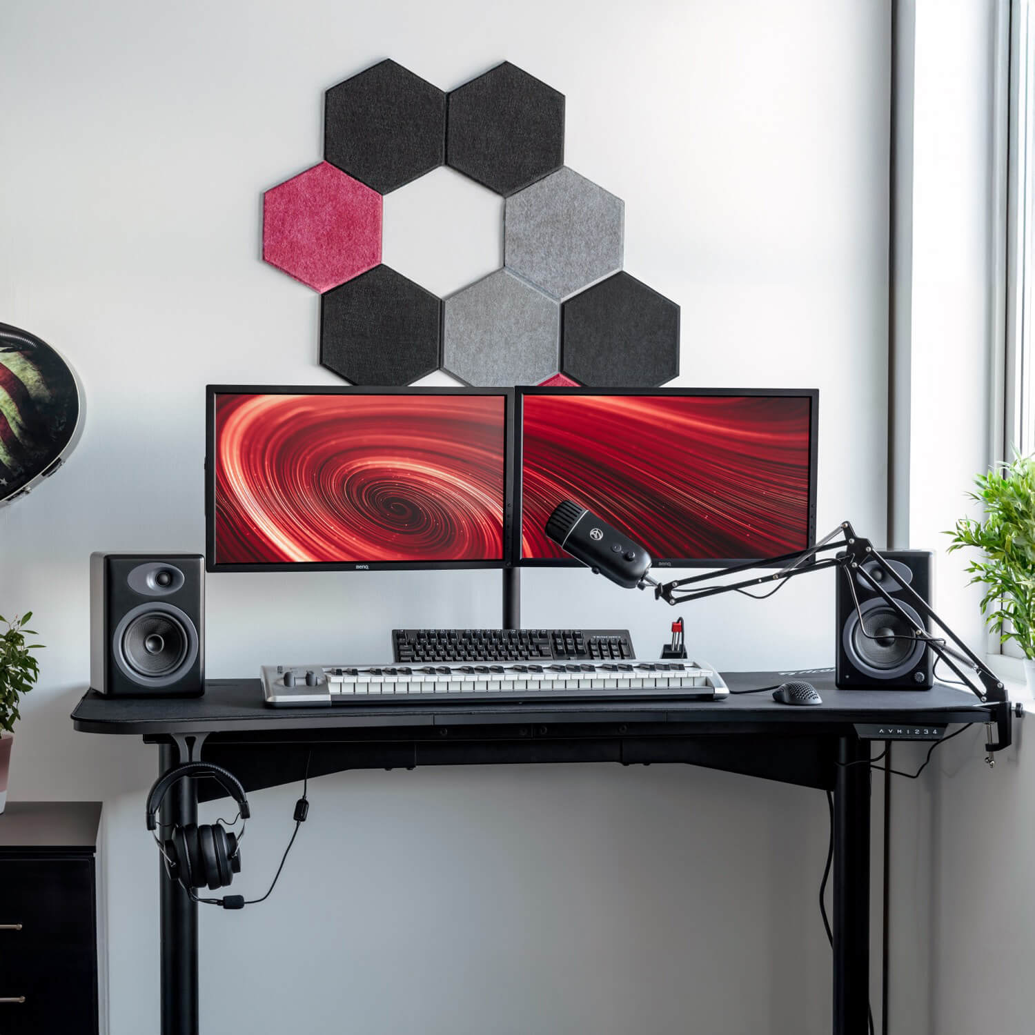 Una postazione da scrivania con doppio monitor, tastiera, mouse, microfono e altoparlanti.