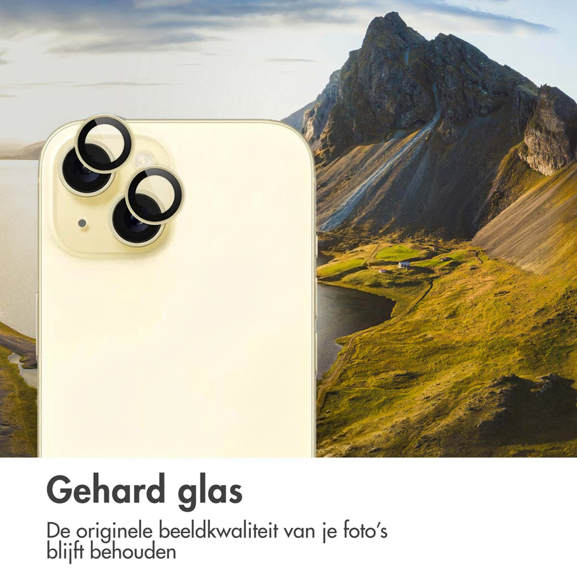 A light yellow smartphone with camera lens protectors in front of a mountain landscape.