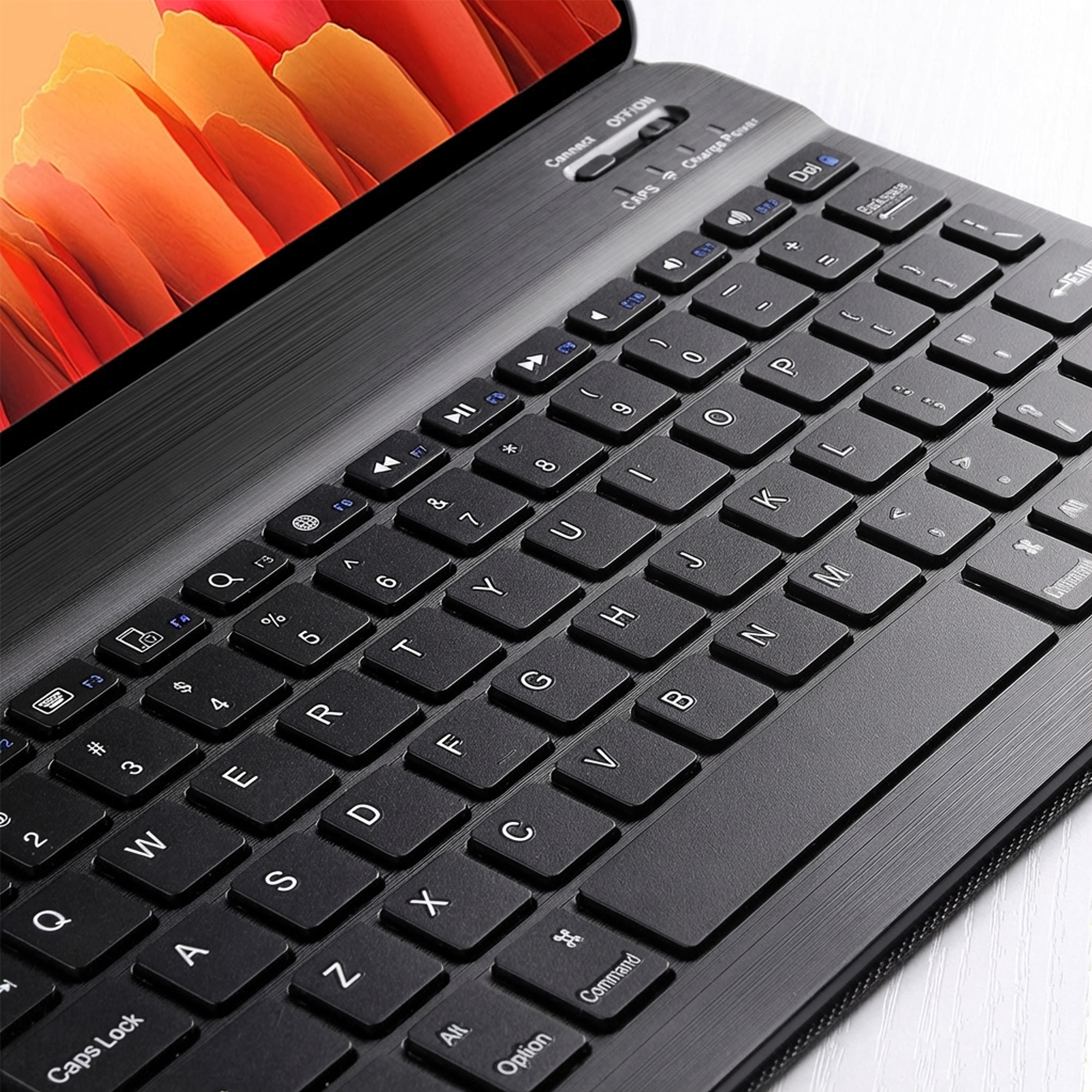 Black keyboard with a tablet screen showing red and orange abstract shapes.