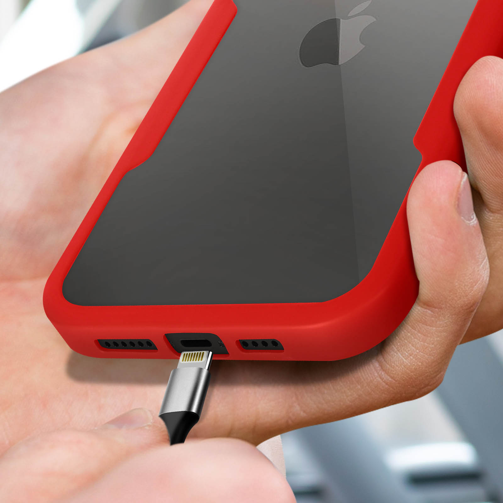 Handen laden een rode iPhone op met lightning kabel. Apple logo zichtbaar.