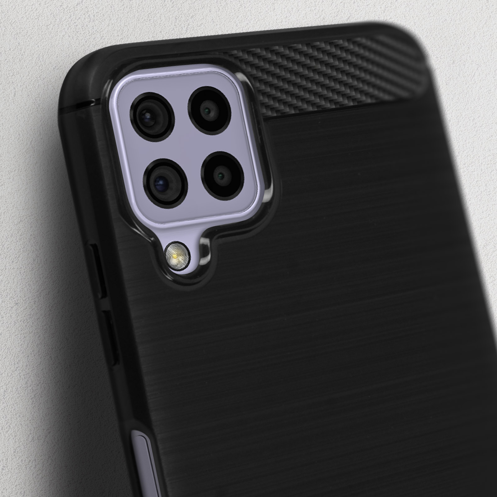 Smartphone nero con quattro fotocamere e flash su sfondo testurizzato.