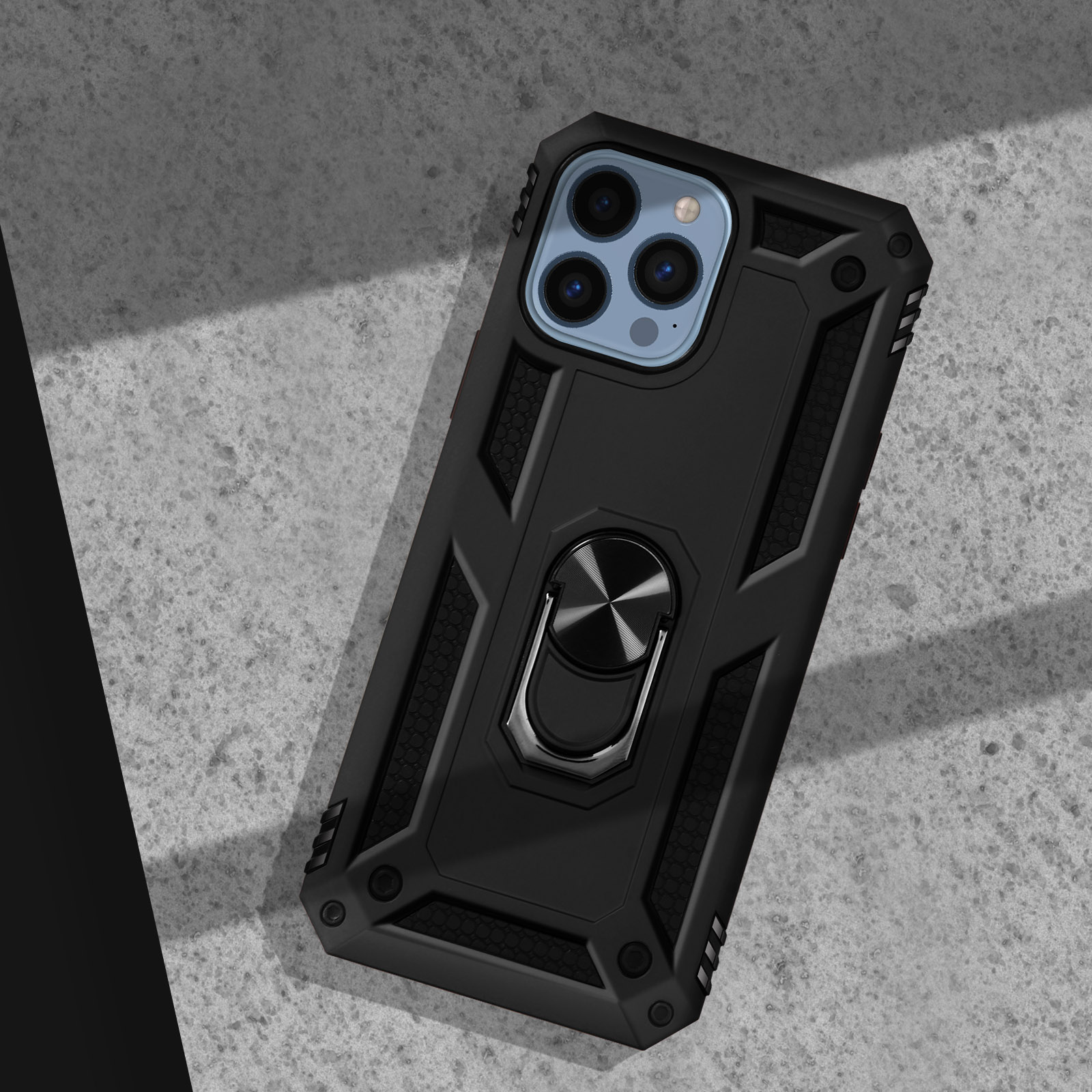 Coque de téléphone noire avec support bague sur surface en béton, éclairée par une lumière oblique.
