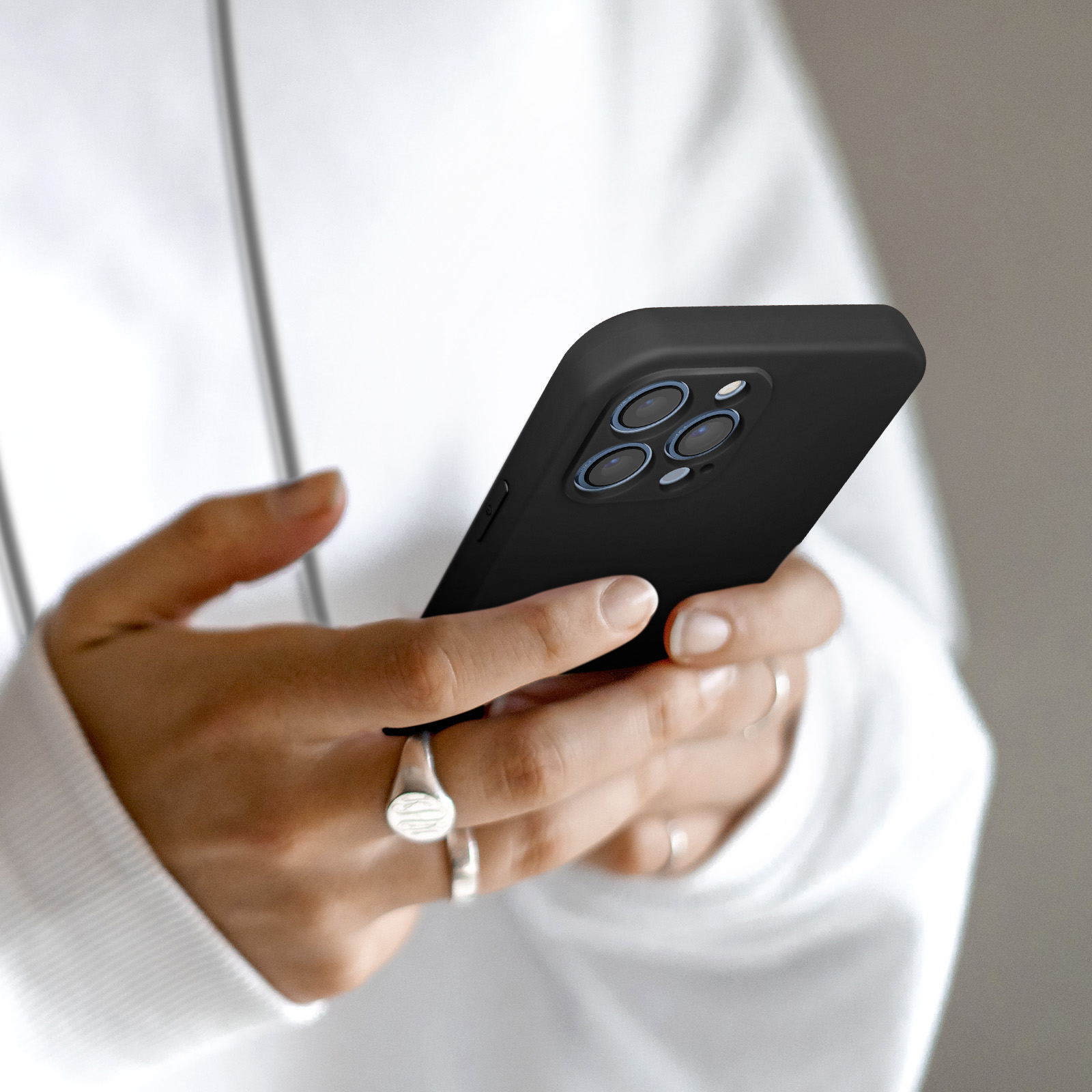 Een persoon houdt een zwarte smartphone met vier camera's vast.