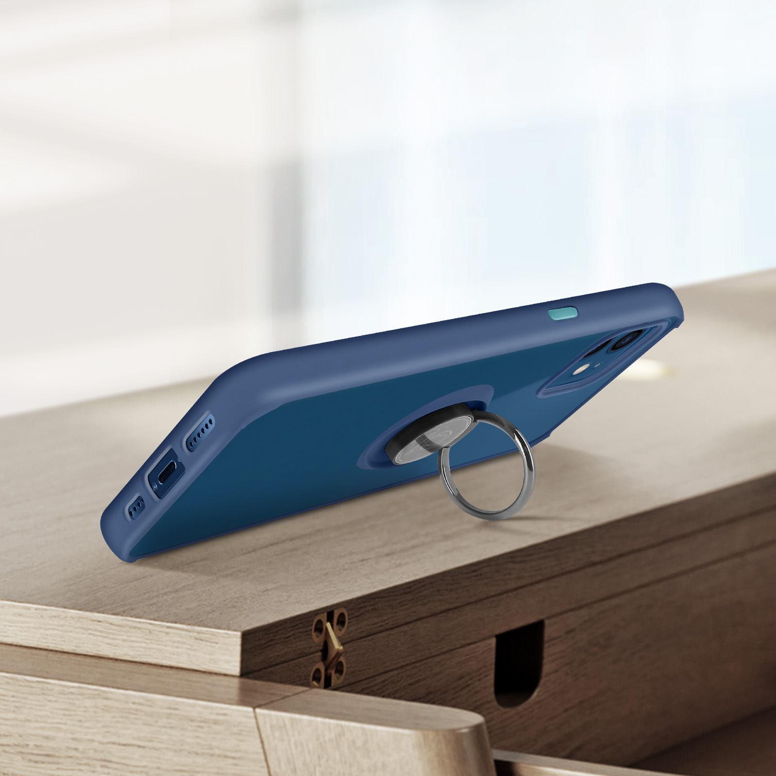 Una custodia blu scuro per telefono con anello porta anello su un tavolo di legno.