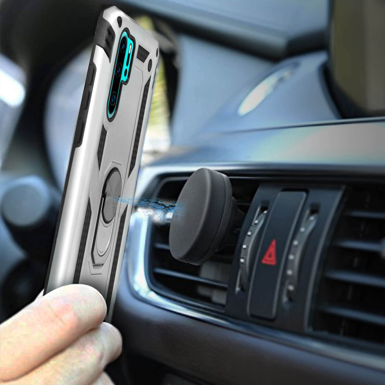 Una cover argentata per telefono con anello di supporto è tenuta vicino a una presa d'aria per auto con supporto magnetico.