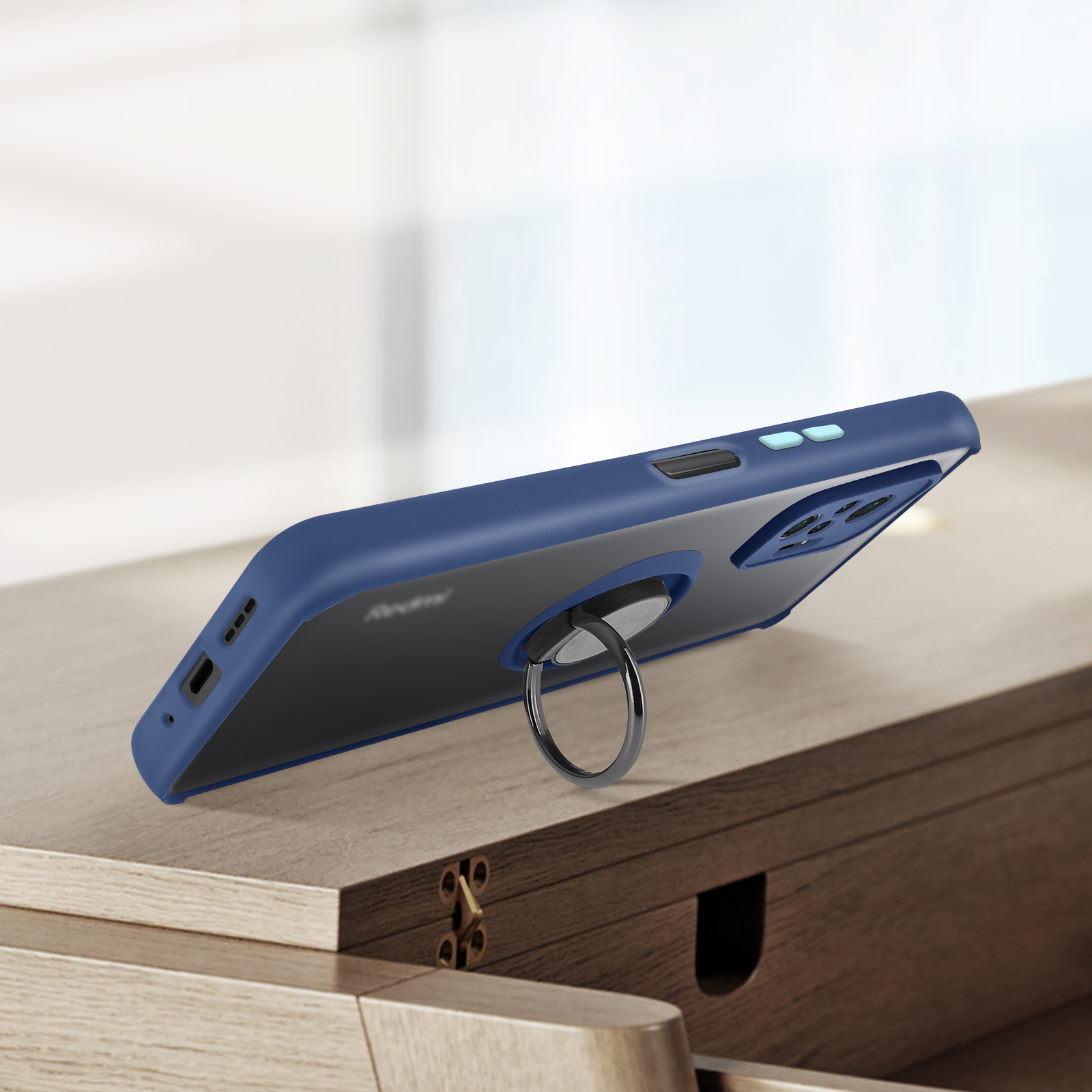 Donkerblauwe telefoonhoes met ringhouder op houten tafel.