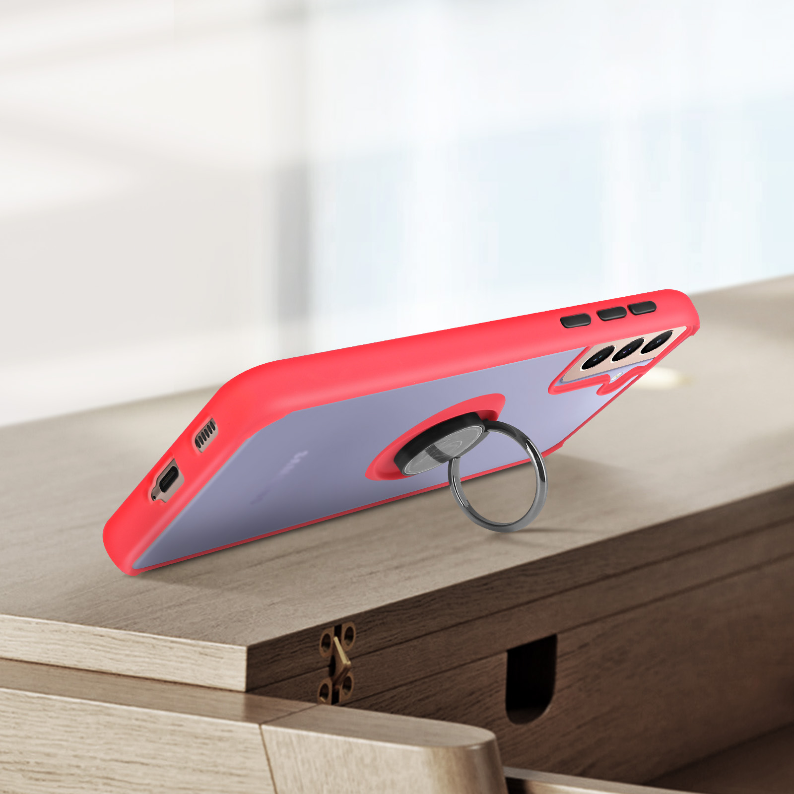 Une coque de téléphone rouge avec dos transparent et support anneau argenté.