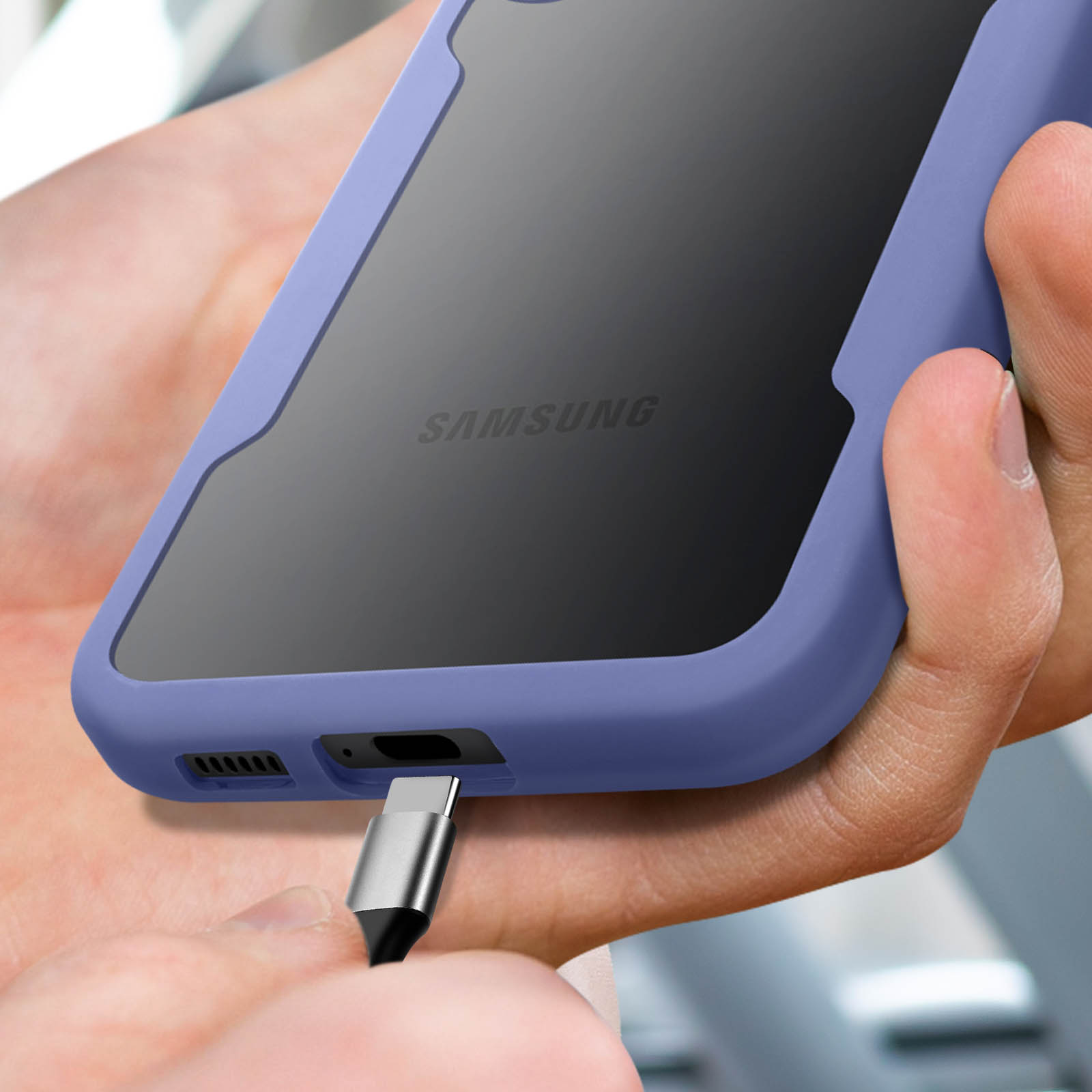 Une main insère un câble USB-C dans un téléphone Samsung violet.