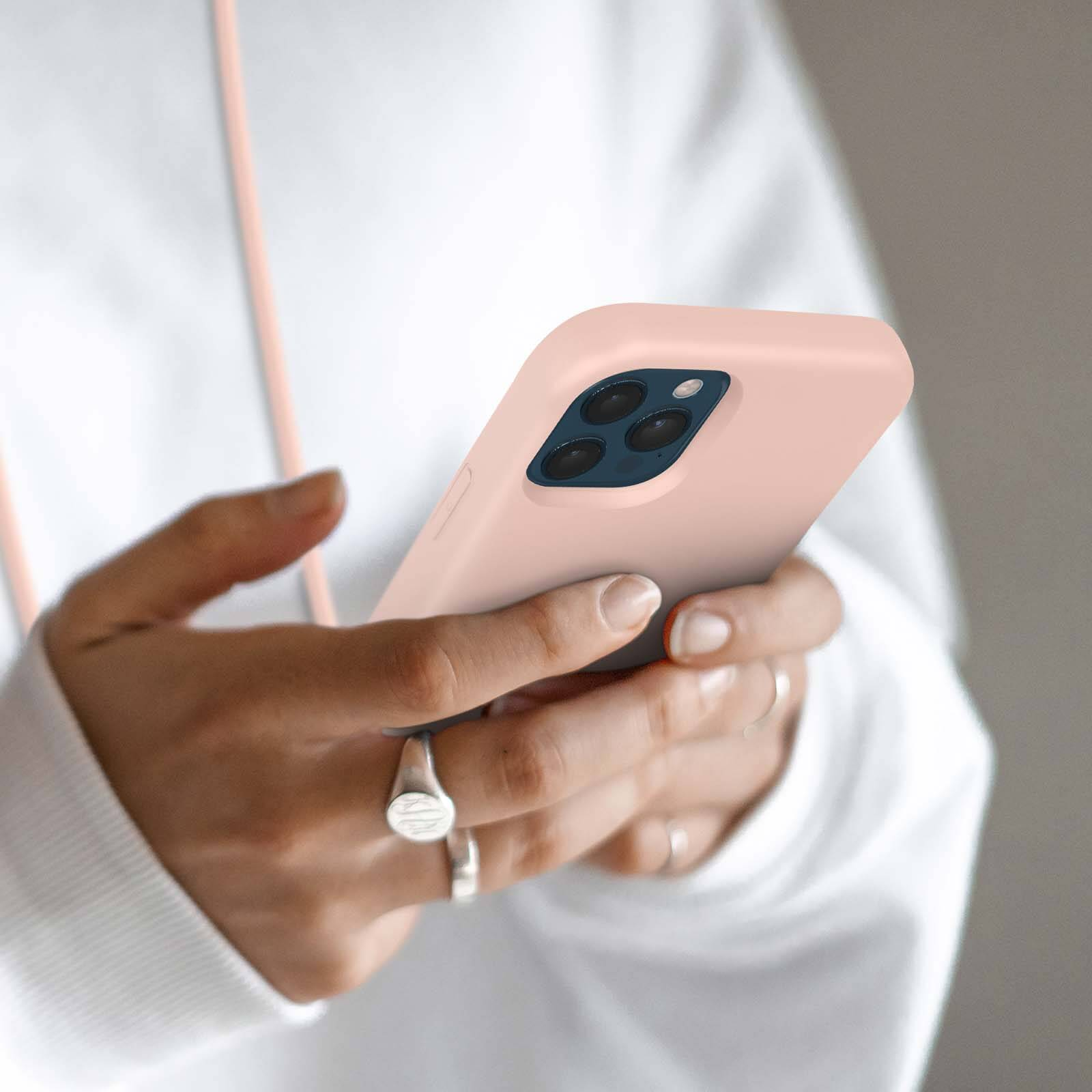 Une personne tient un iPhone rose avec triple appareil photo.