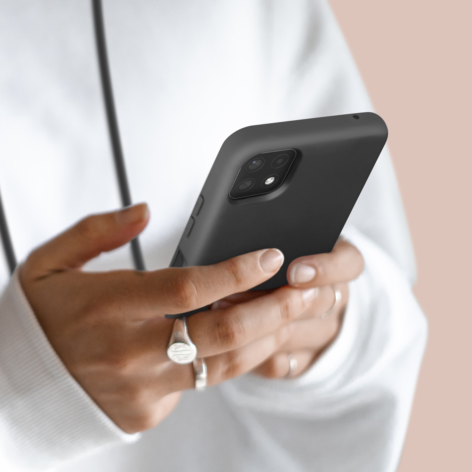 Een persoon houdt een zwarte smartphone met vier camera's vast.