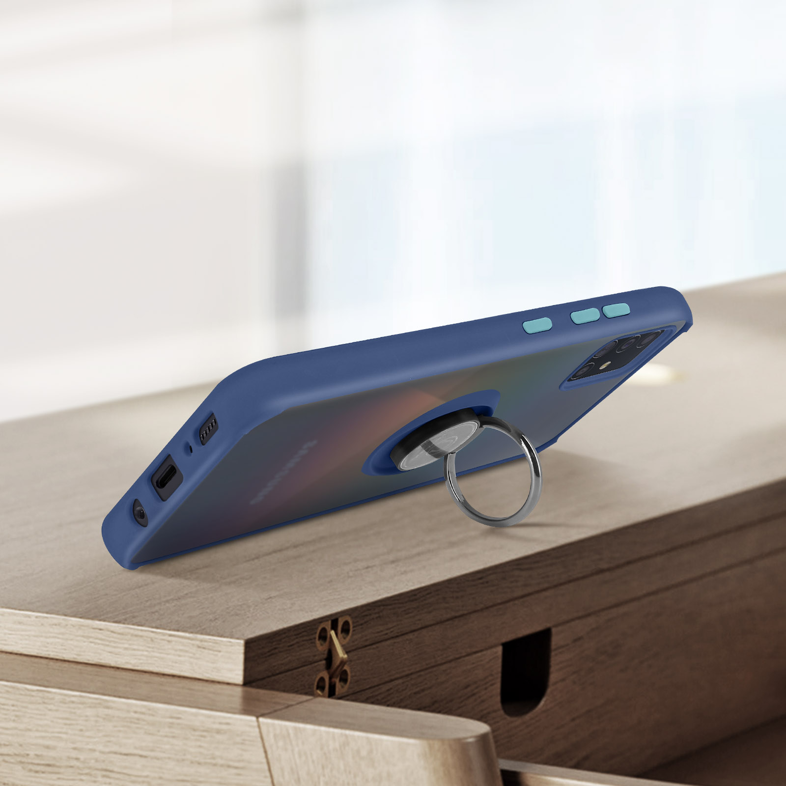 Donkerblauw telefoonhoesje met ringhouder op houten tafel.