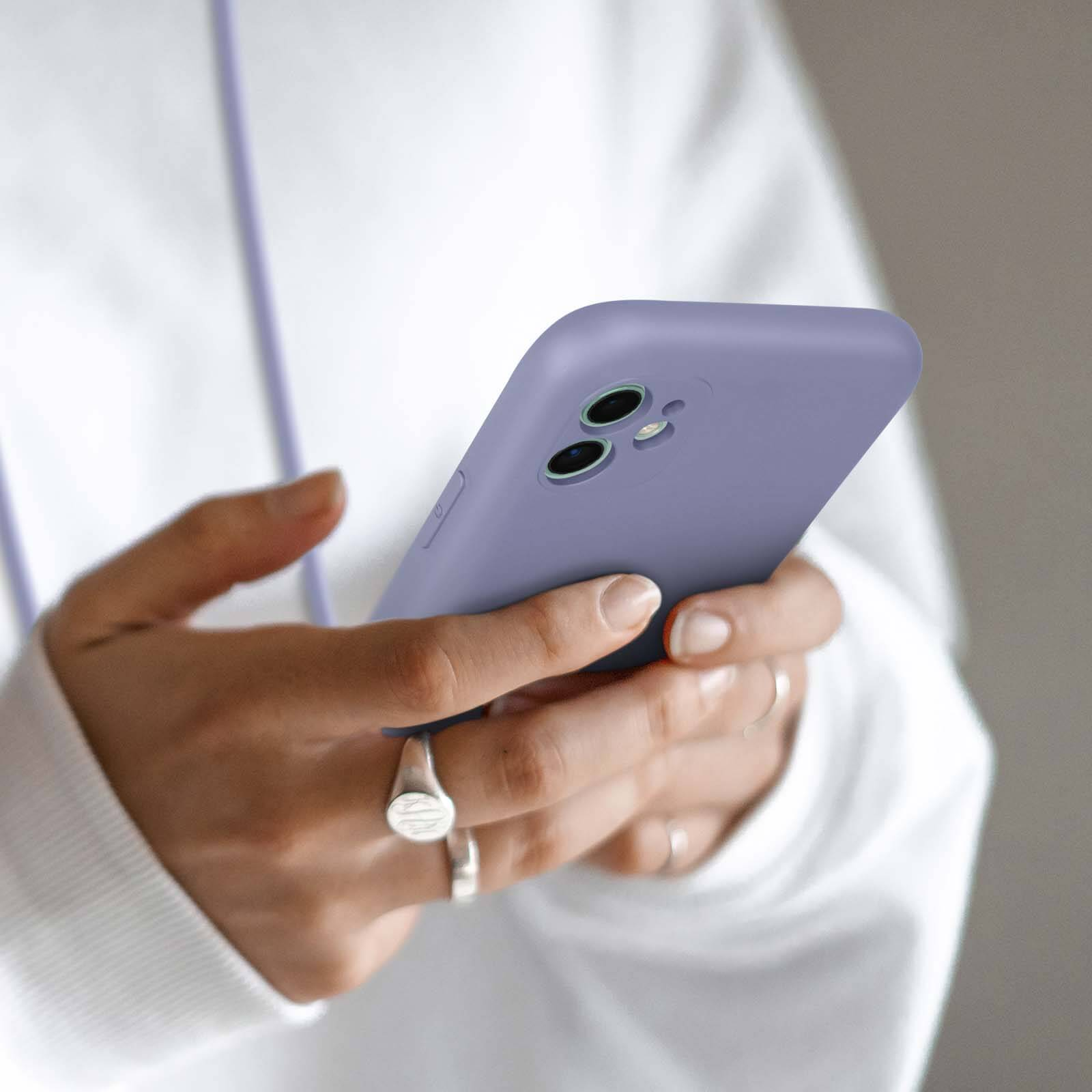 Een persoon houdt een paarse smartphone met twee camera's vast.