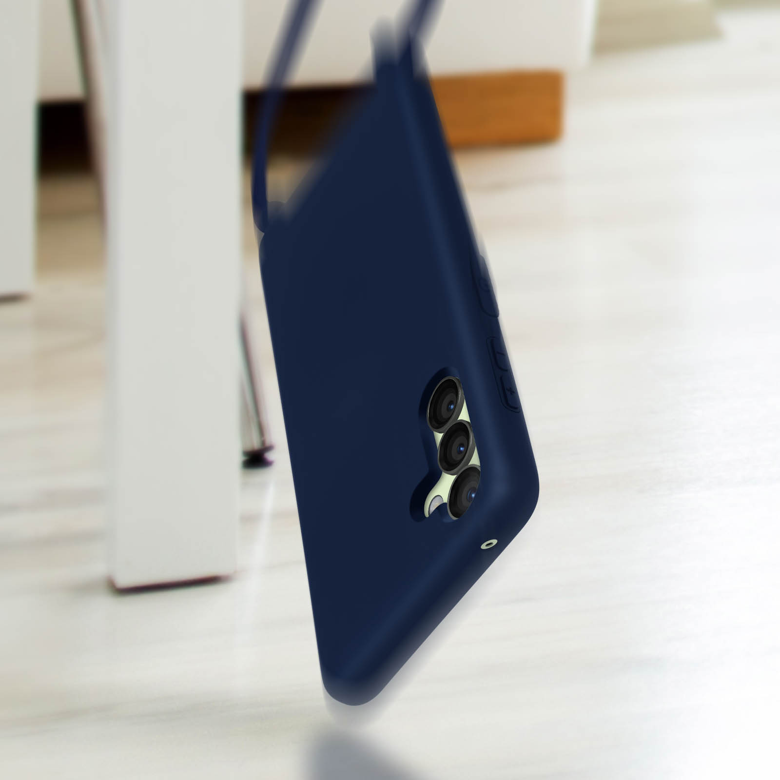 Une coque de téléphone bleu foncé avec trois caméras repose sur une surface claire.