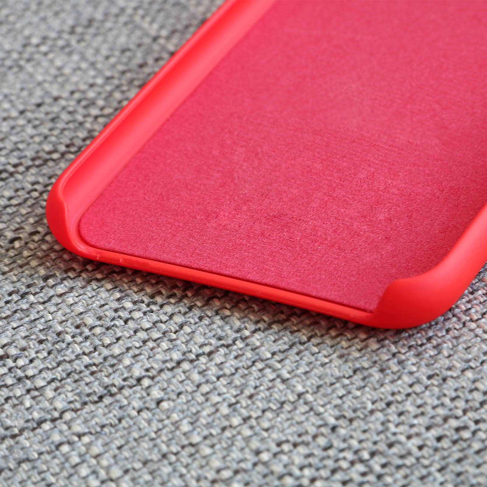 Coque de téléphone rouge sur fond de tissu texturé.