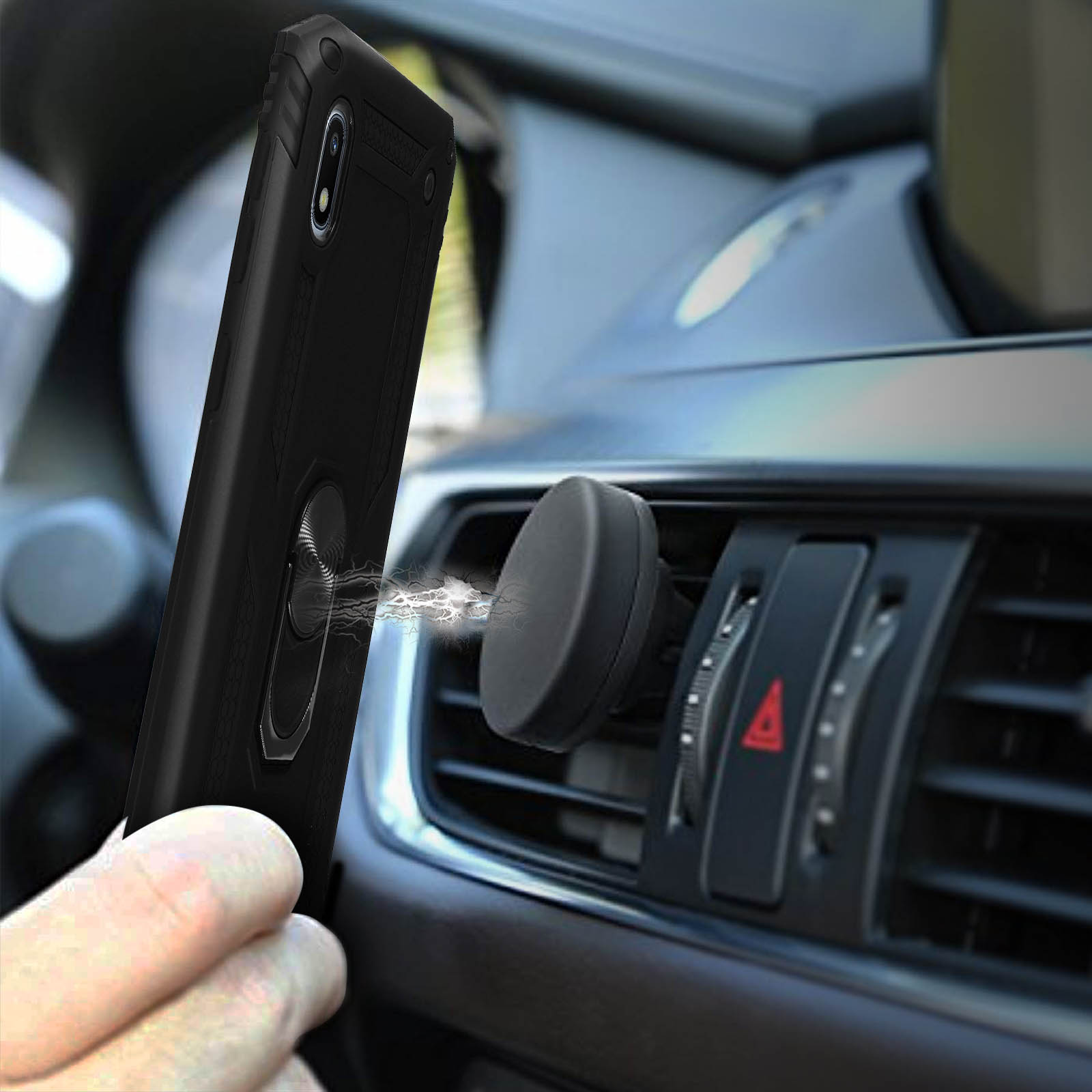 Une main tient un téléphone noir avec support anneau près d'une bouche d'aération magnétique de voiture.