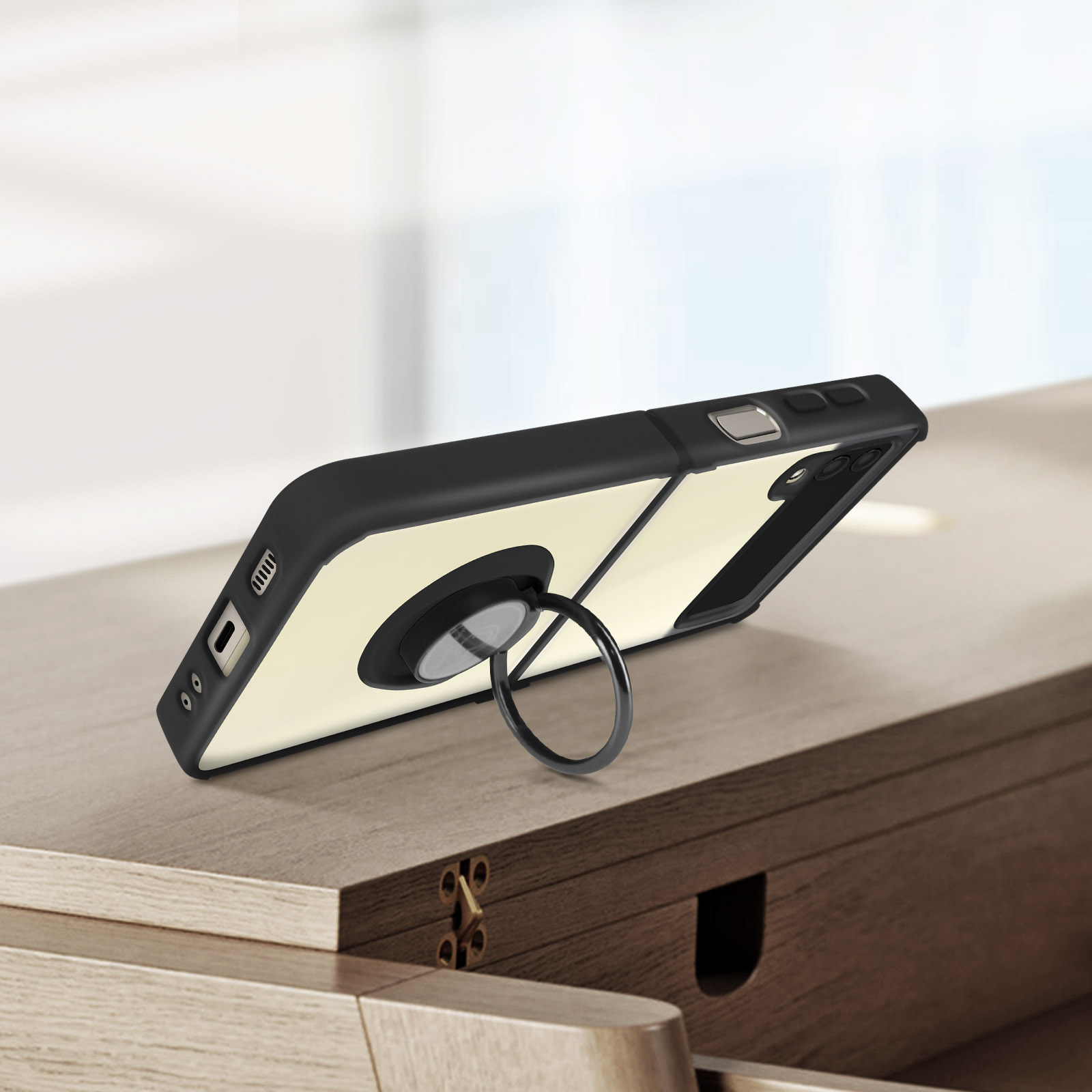 Un telefono nero con anello porta-telefono su un tavolo di legno.