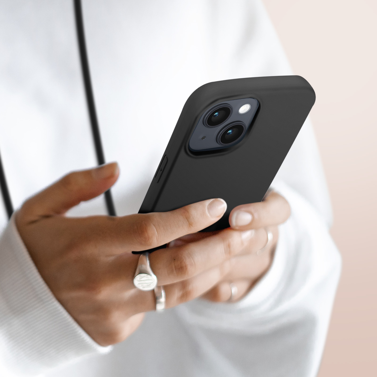Een persoon houdt een zwarte smartphone met twee camera's vast.