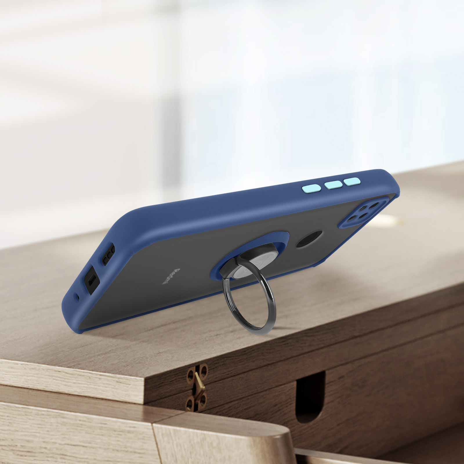 Coque de téléphone bleu foncé avec support anneau sur table en bois.