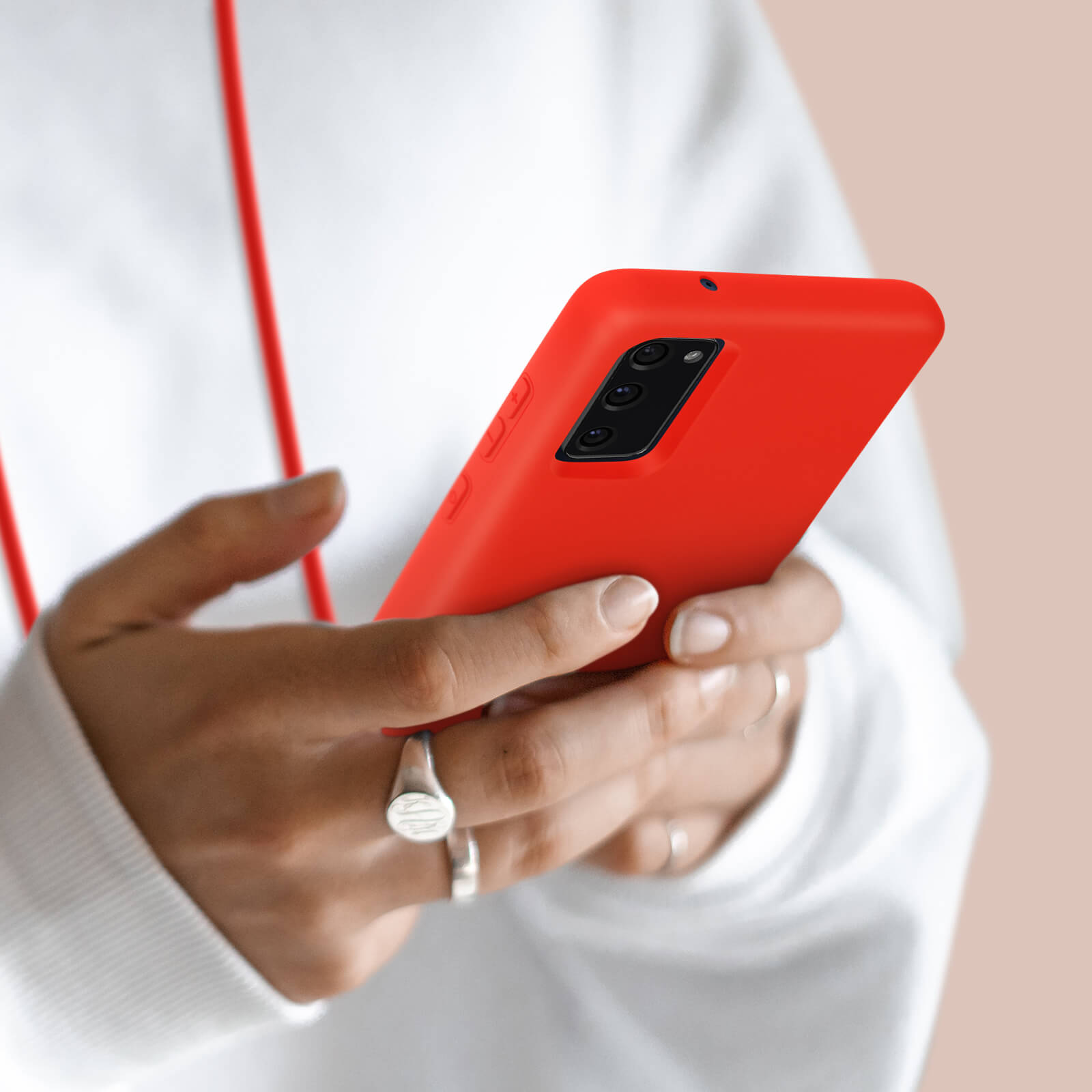 Personne tenant un téléphone rouge avec trois objectifs.