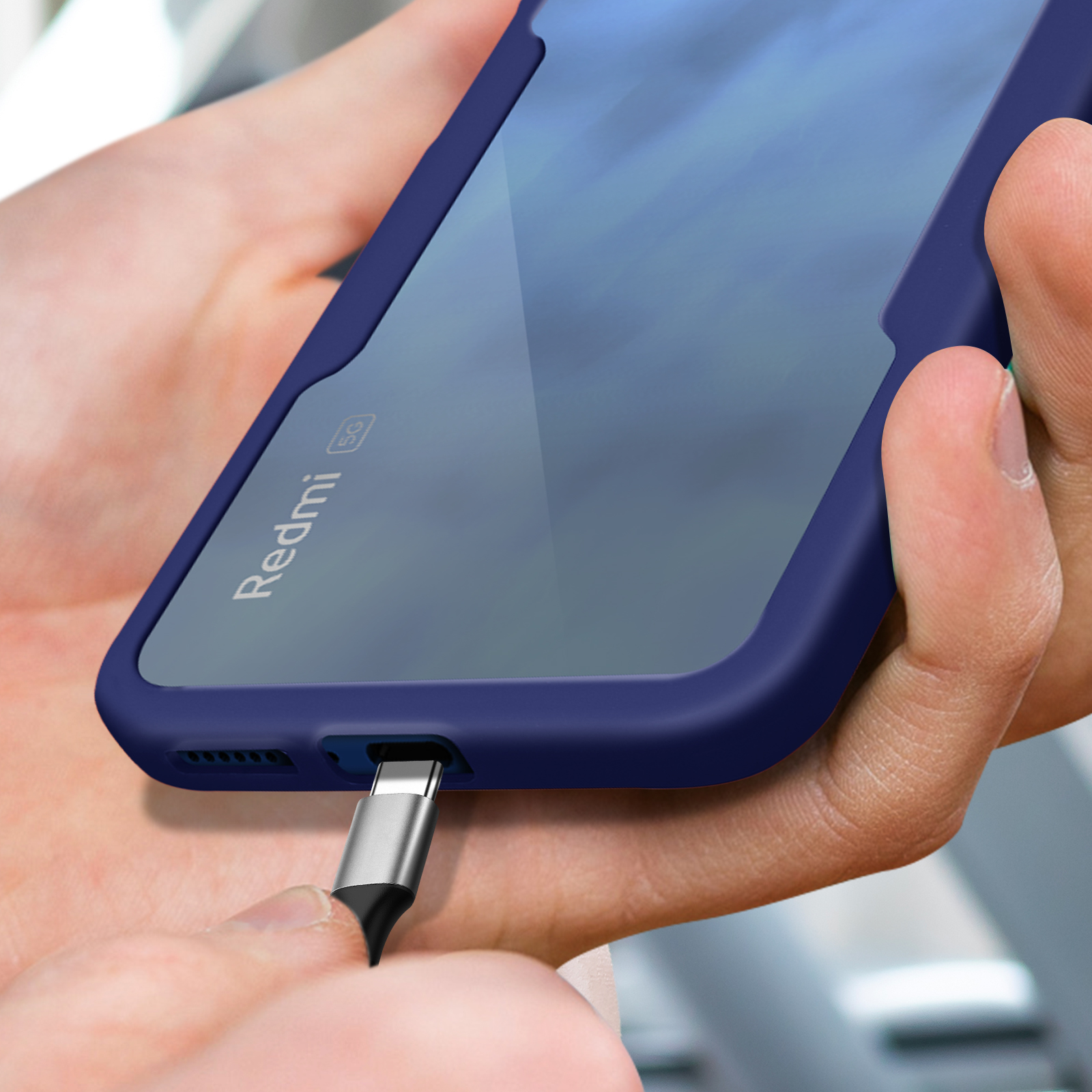 Un téléphone avec un étui bleu est relié par un câble USB-C.