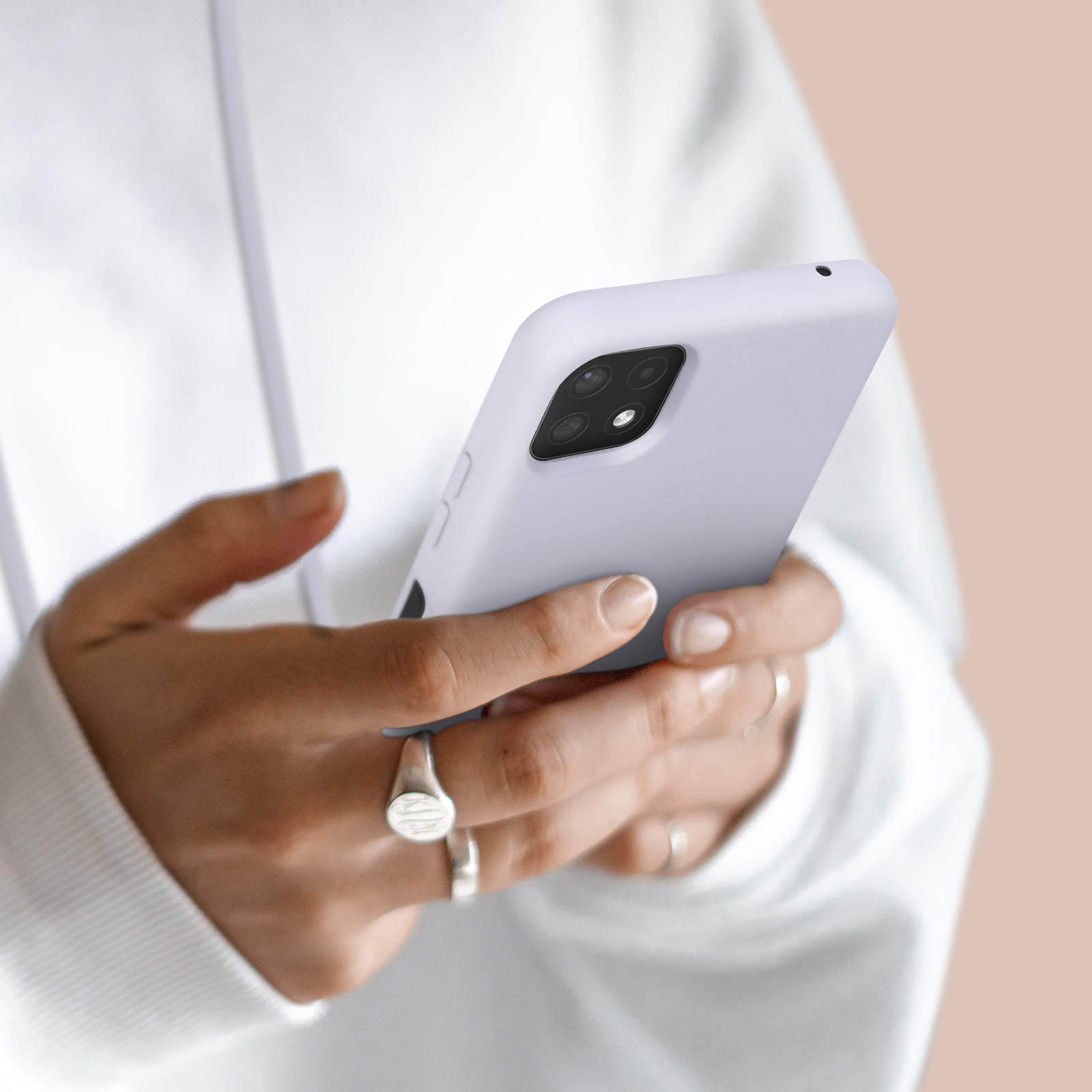 Mains tenant un smartphone lilas. Gros plan.