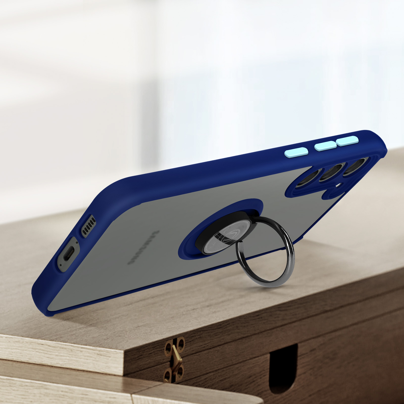Coque de téléphone bleu foncé avec dos transparent et support anneau sur table bois.
