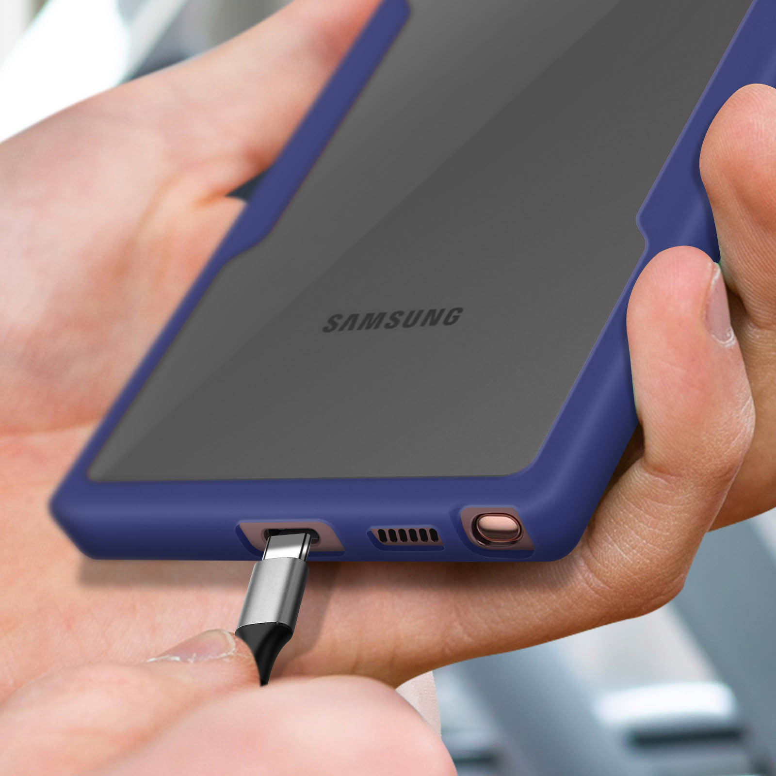 Un câble USB-C est branché sur un smartphone avec une coque bleue.