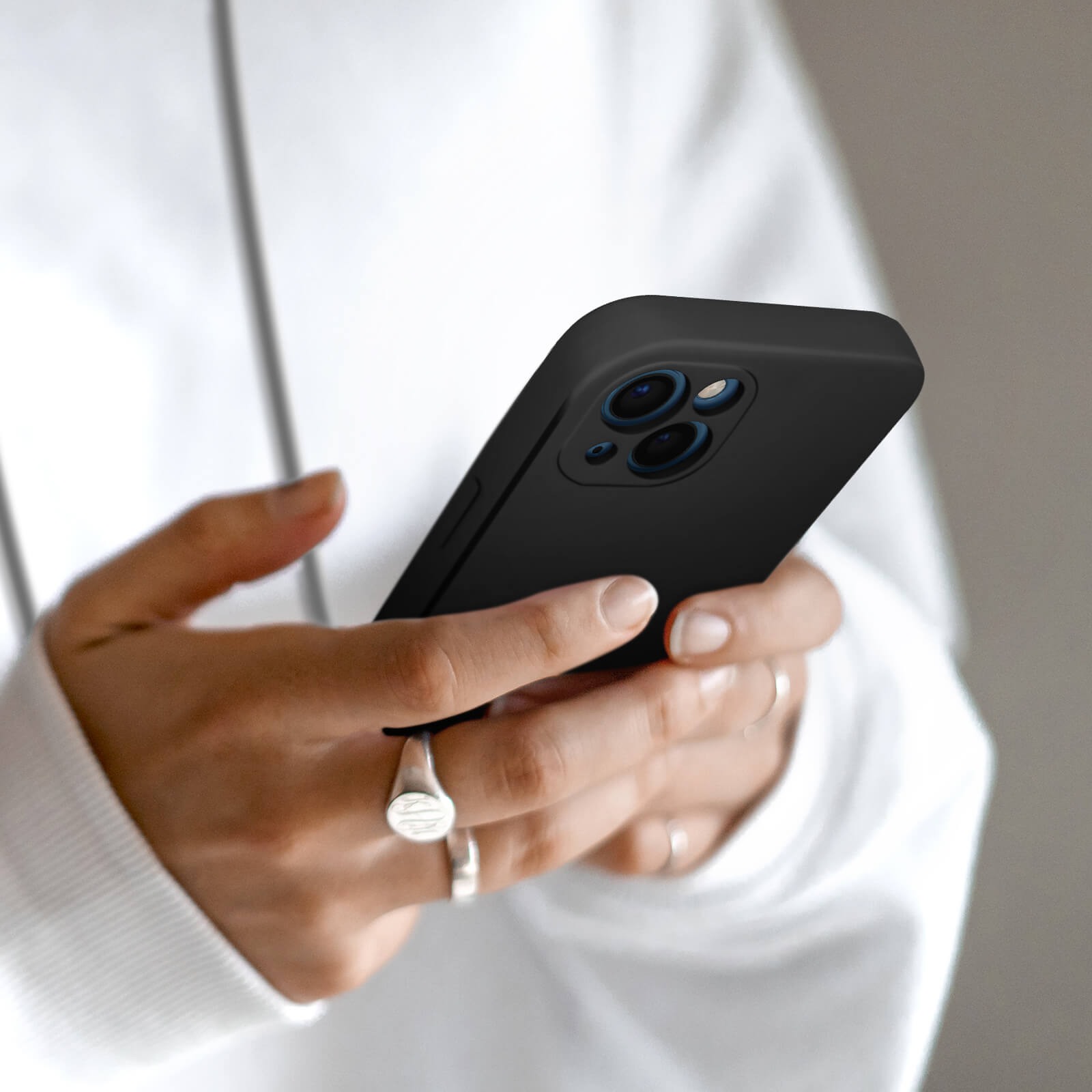 Una persona tiene uno smartphone nero con tre fotocamere.