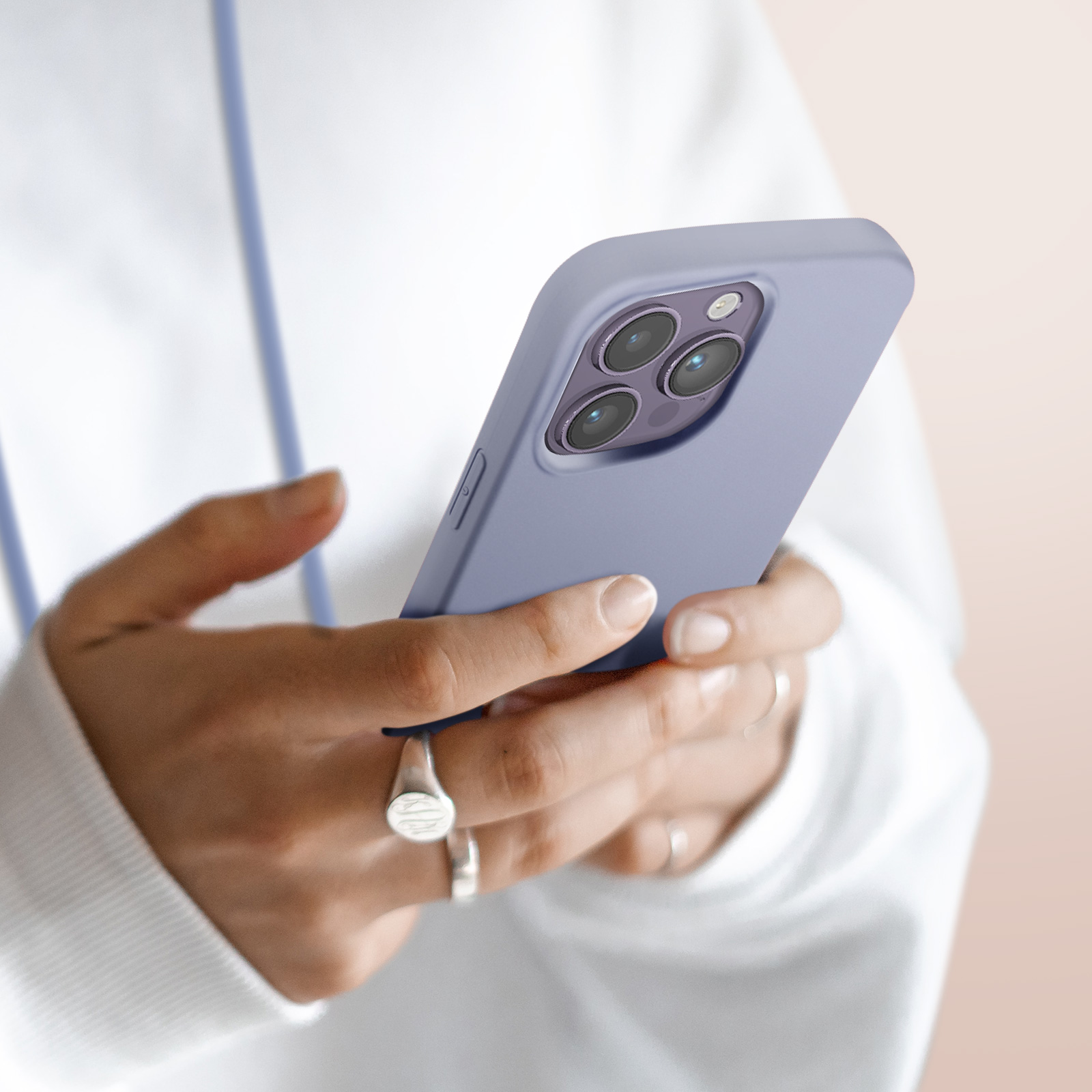 Gros plan de mains tenant une coque de téléphone violette avec trois objectifs d'appareil photo.