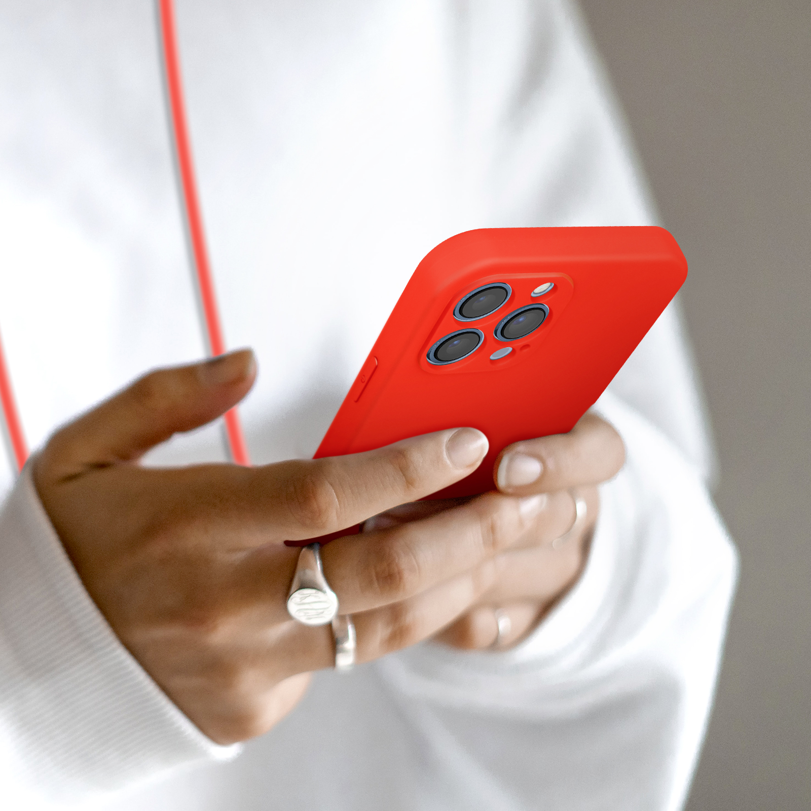 Persona che tiene uno smartphone rosso con quattro fotocamere.