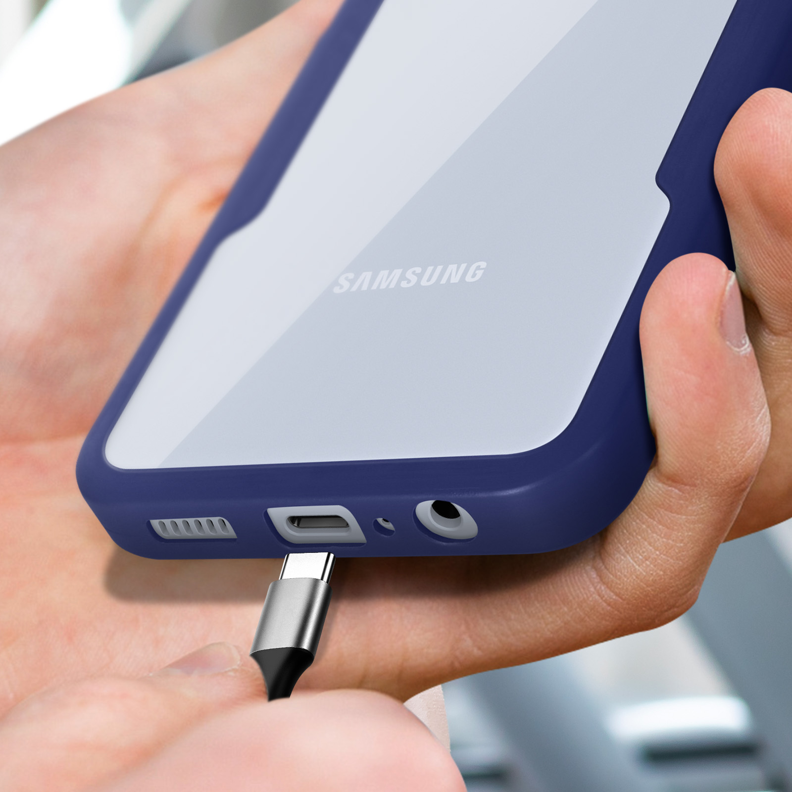 Un câble USB-C est branché sur un smartphone Samsung avec un étui bleu foncé.