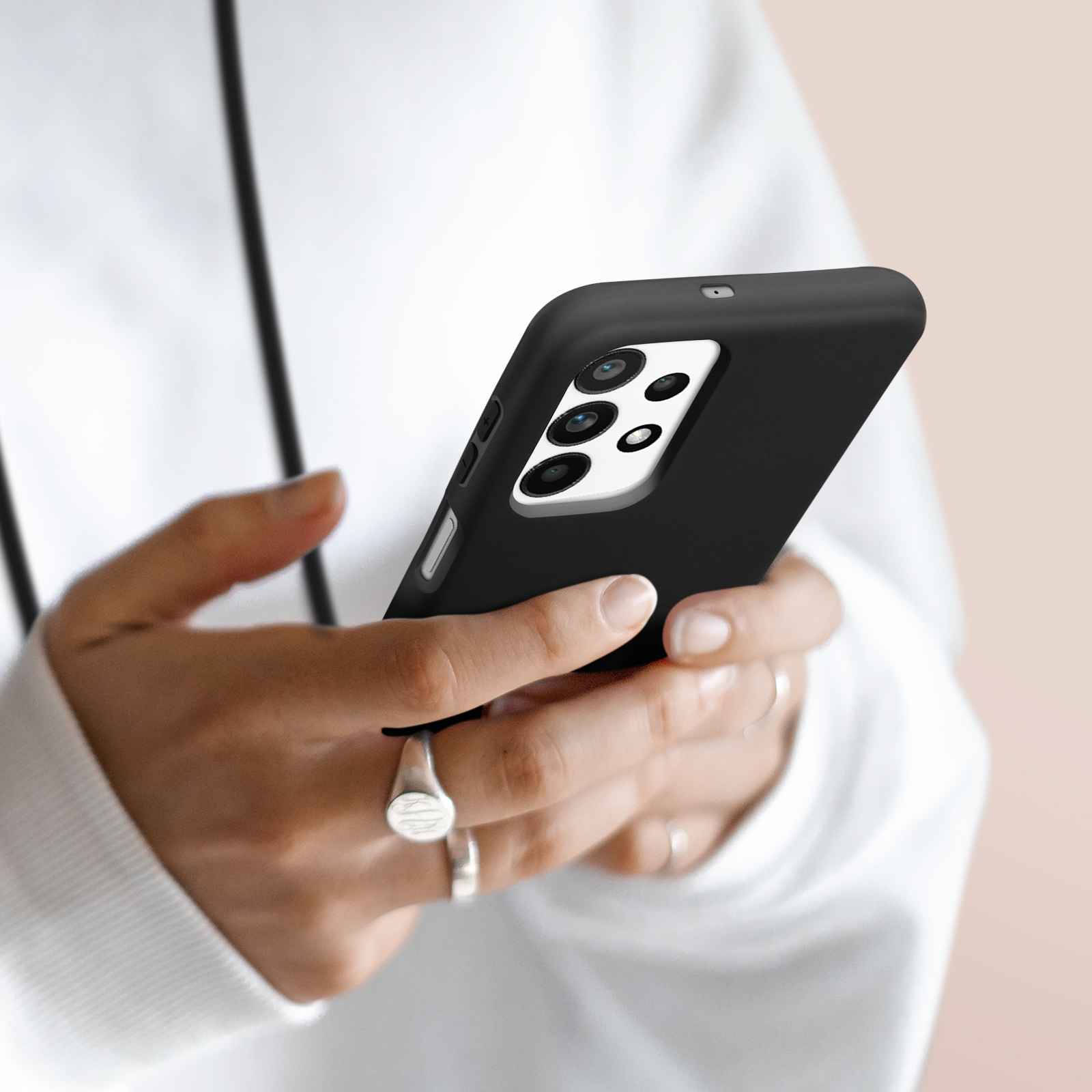 Mains tenant un smartphone noir avec plusieurs appareils photo.
