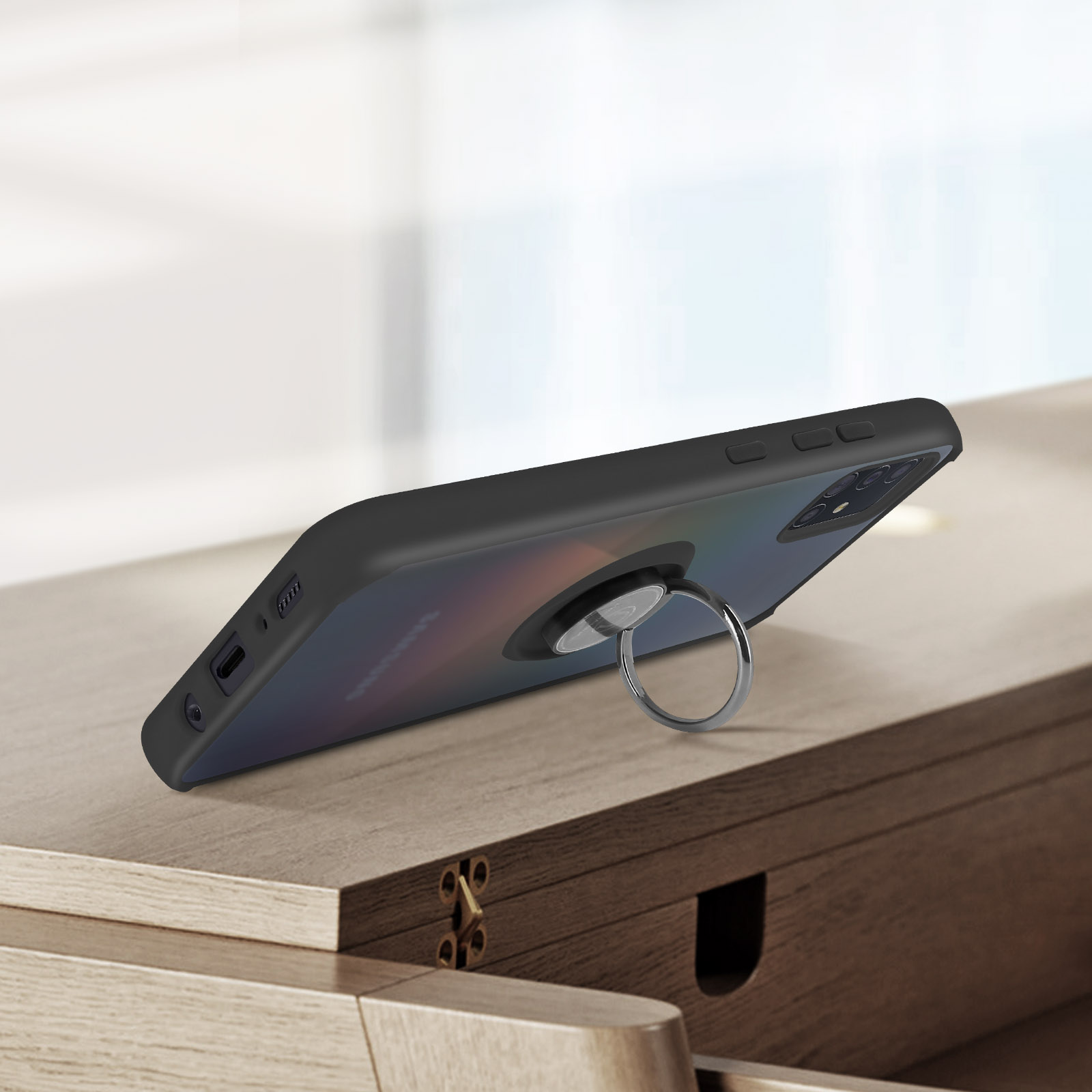 Téléphone noir avec support anneau sur table en bois, vue rapprochée.
