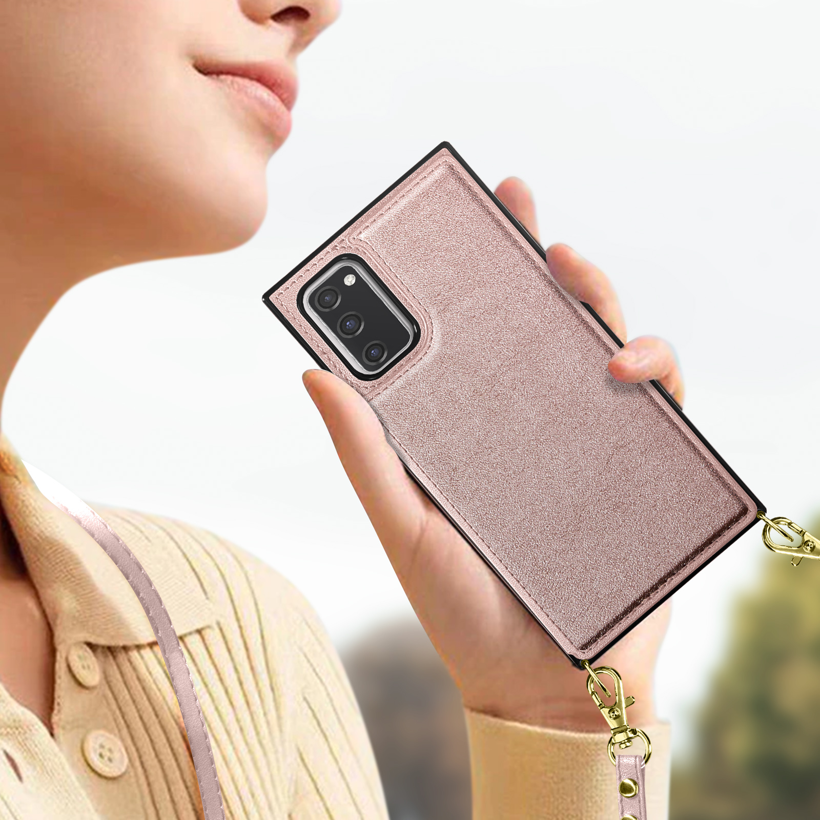 Een persoon houdt een roségouden telefoon met meerdere camera's vast.