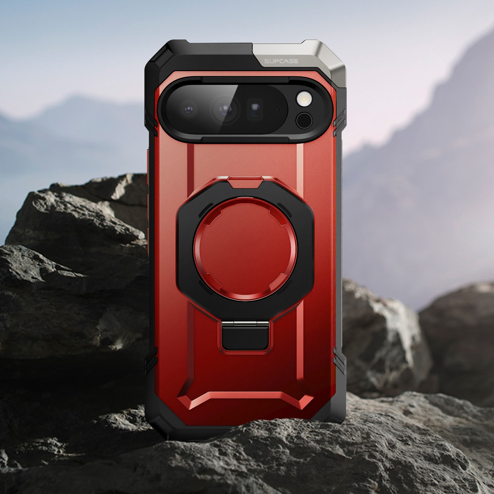 Rotes Handy-Case mit schwarzem Ring und Kameras auf felsiger Landschaft.
