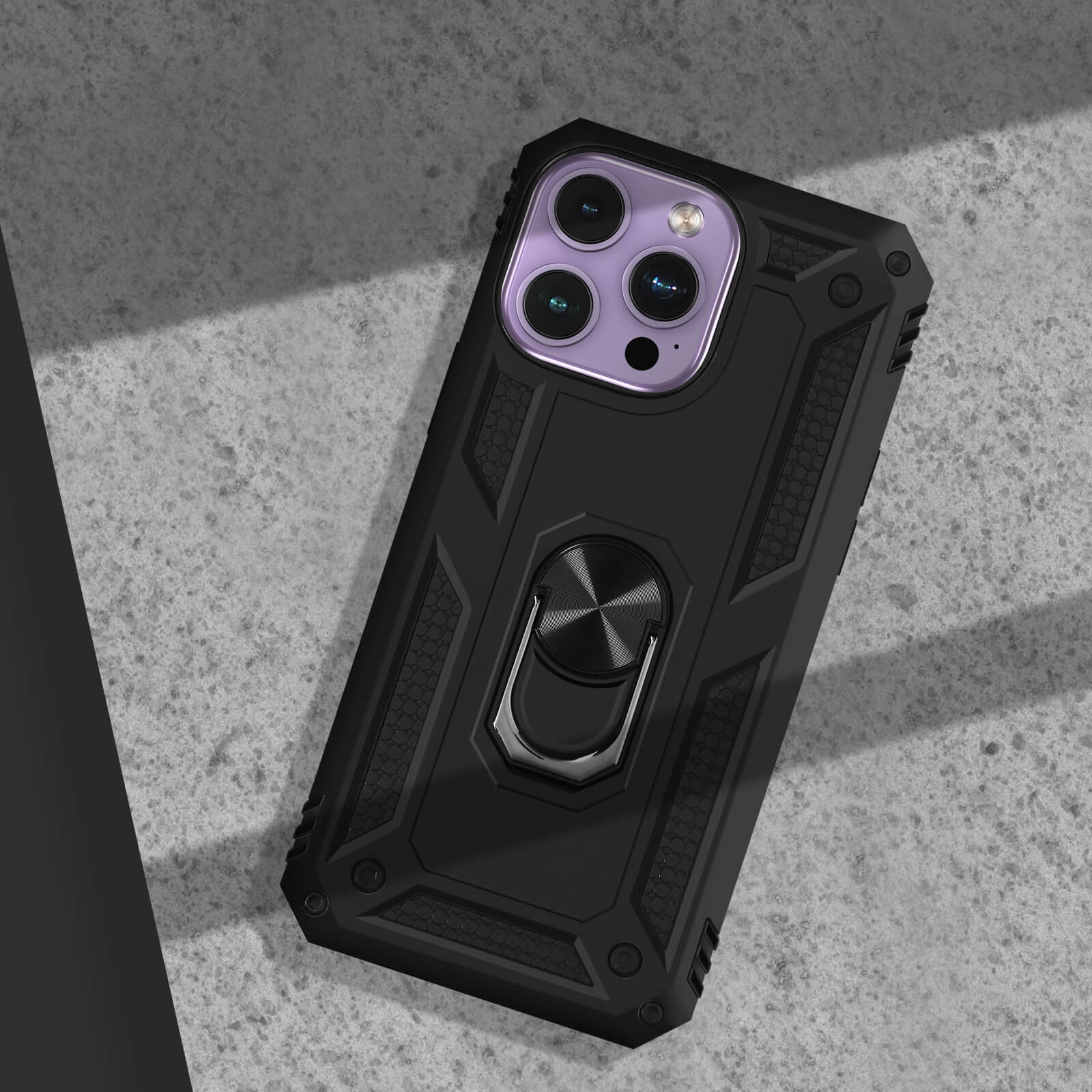 Coque de téléphone noire avec support bague sur surface bétonnée, à l'ombre.