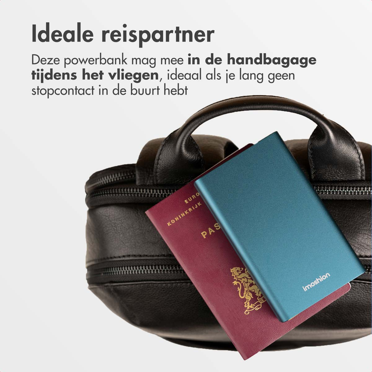 Une power bank bleue repose sur un passeport rouge devant un sac noir.