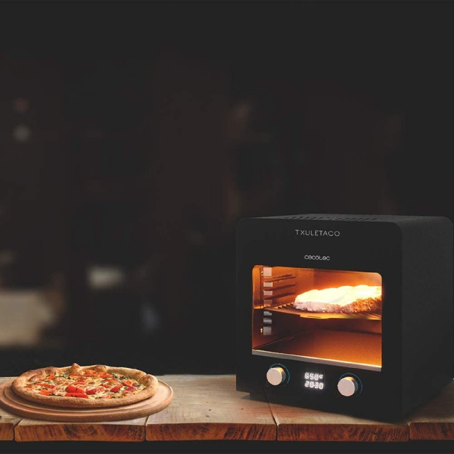 Een afgebakken pizza naast een zwarte oven met brood dat bakt.